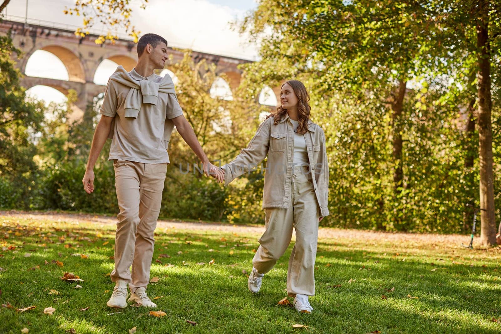 Young Cute Female Hugs Boyfriend. In Autumn Outdoor. Lovers Walking in Park. Attractive Funny Couple. Lovestory in Forest. Man and Woman. Cute Lovers in the Park. Family Concept. Happy Couple.