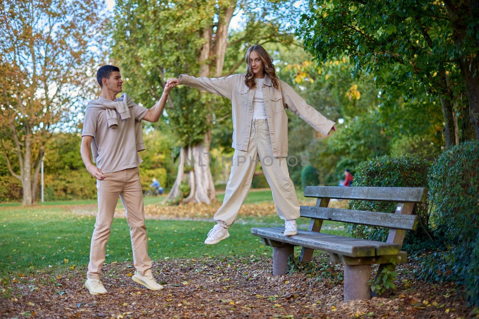 Young Cute Female Hugs Boyfriend. In Autumn Outdoor. Lovers Walking in Park. Attractive Funny Couple. Lovestory in Forest. Man and Woman. Cute Lovers in the Park. Family Concept. Happy Couple.