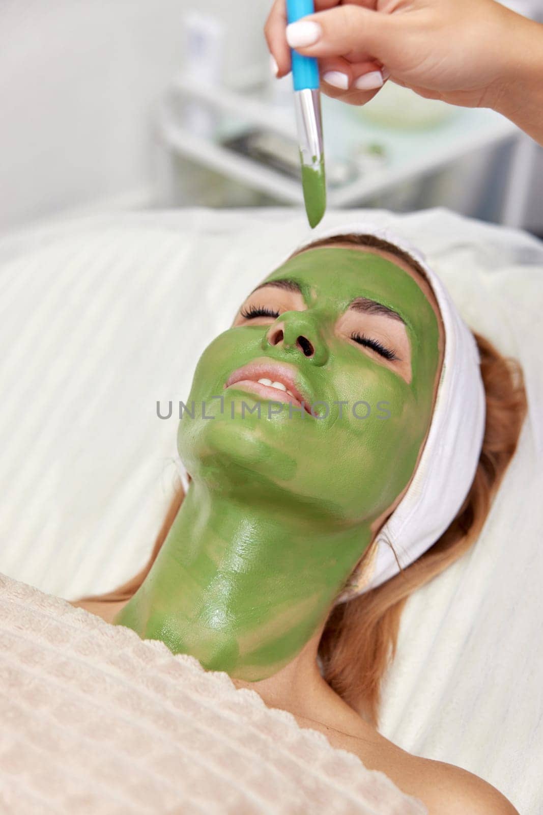 beautiful woman with green alginate mask on face