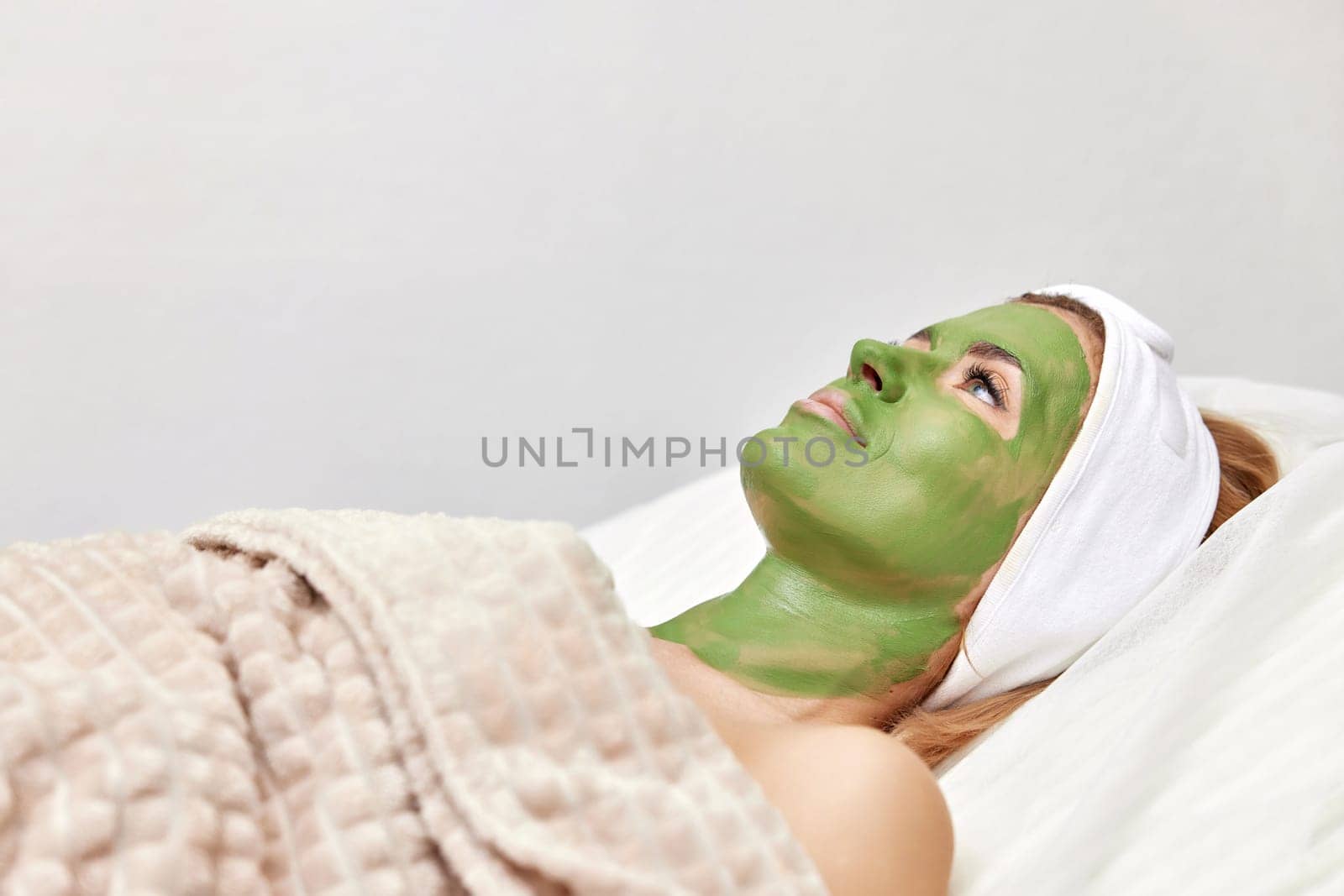 beautiful woman with green alginate mask on face