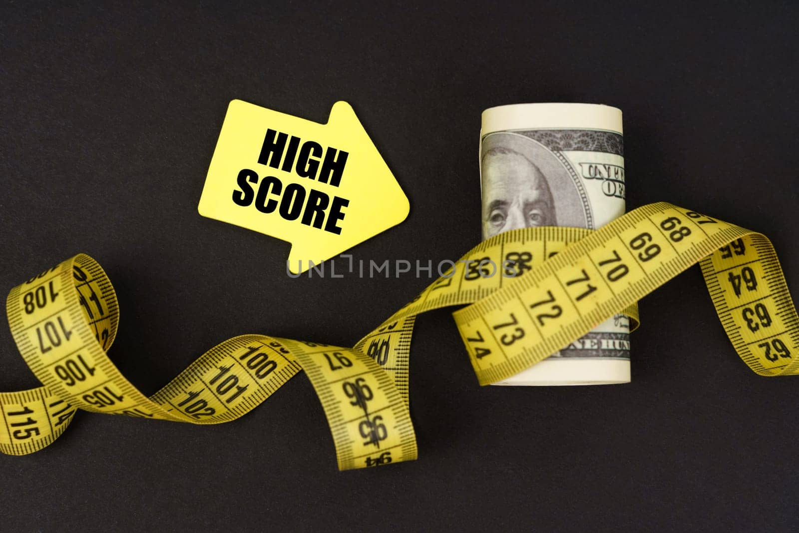 Business concept. On a black surface there are dollars wrapped in measuring tape and stickers with the inscription - High Score