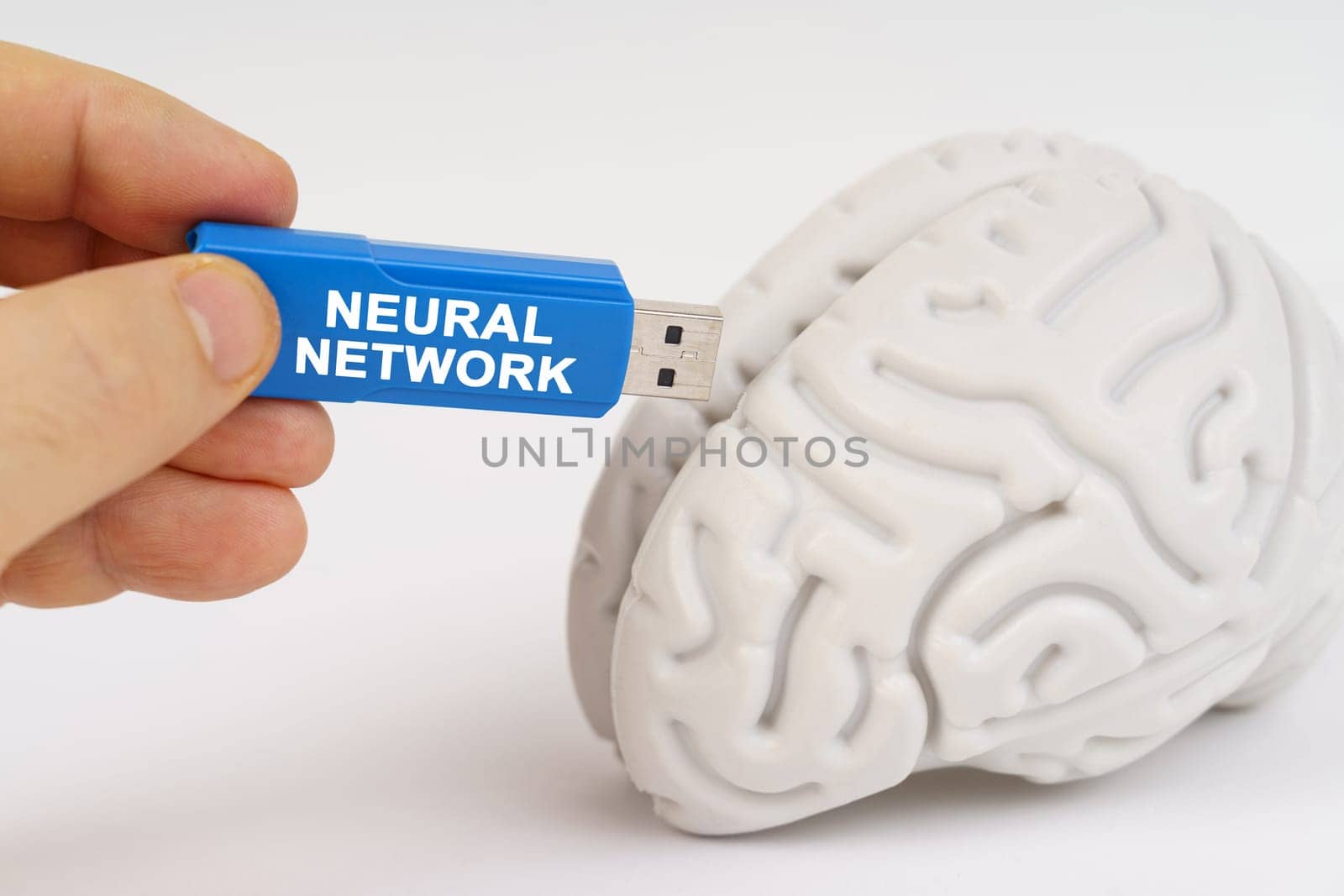A man inserts a flash drive into his brain with the inscription - Neural Network. Education and technology concept.