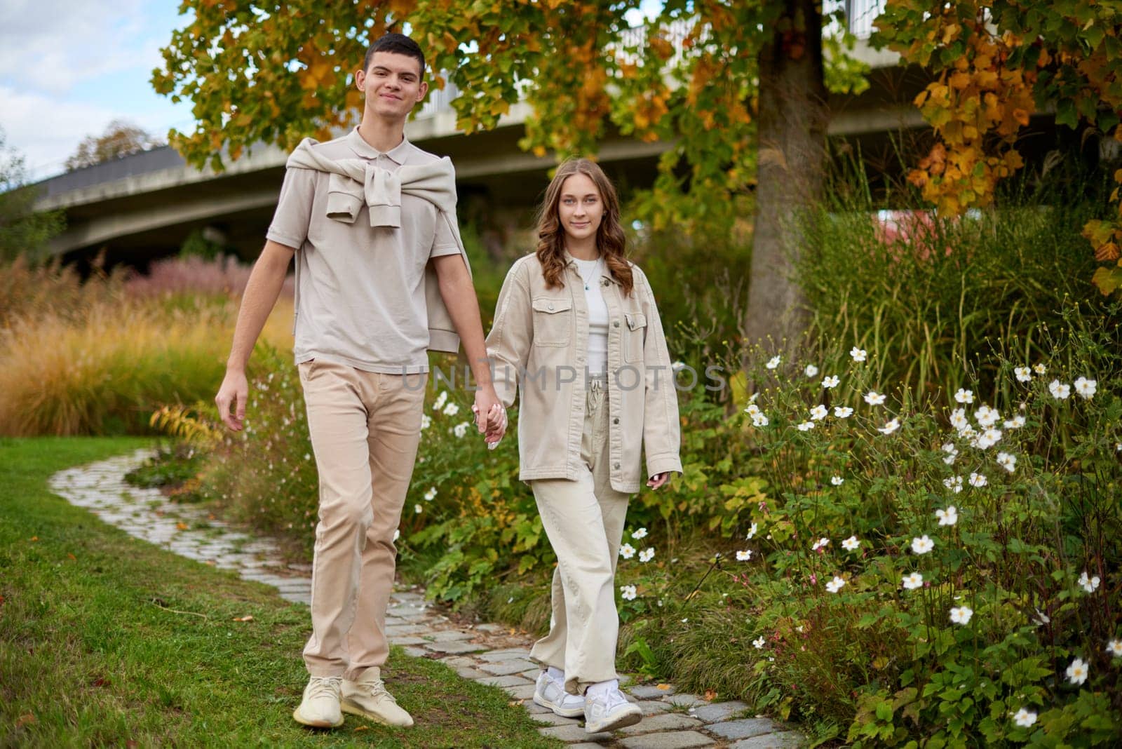 Young Cute Female Hugs Boyfriend. In Autumn Outdoor. Lovers Walking in Park. Attractive Funny Couple. Lovestory in Forest. Man and Woman. Cute Lovers in the Park. Family Concept. Happy Couple.