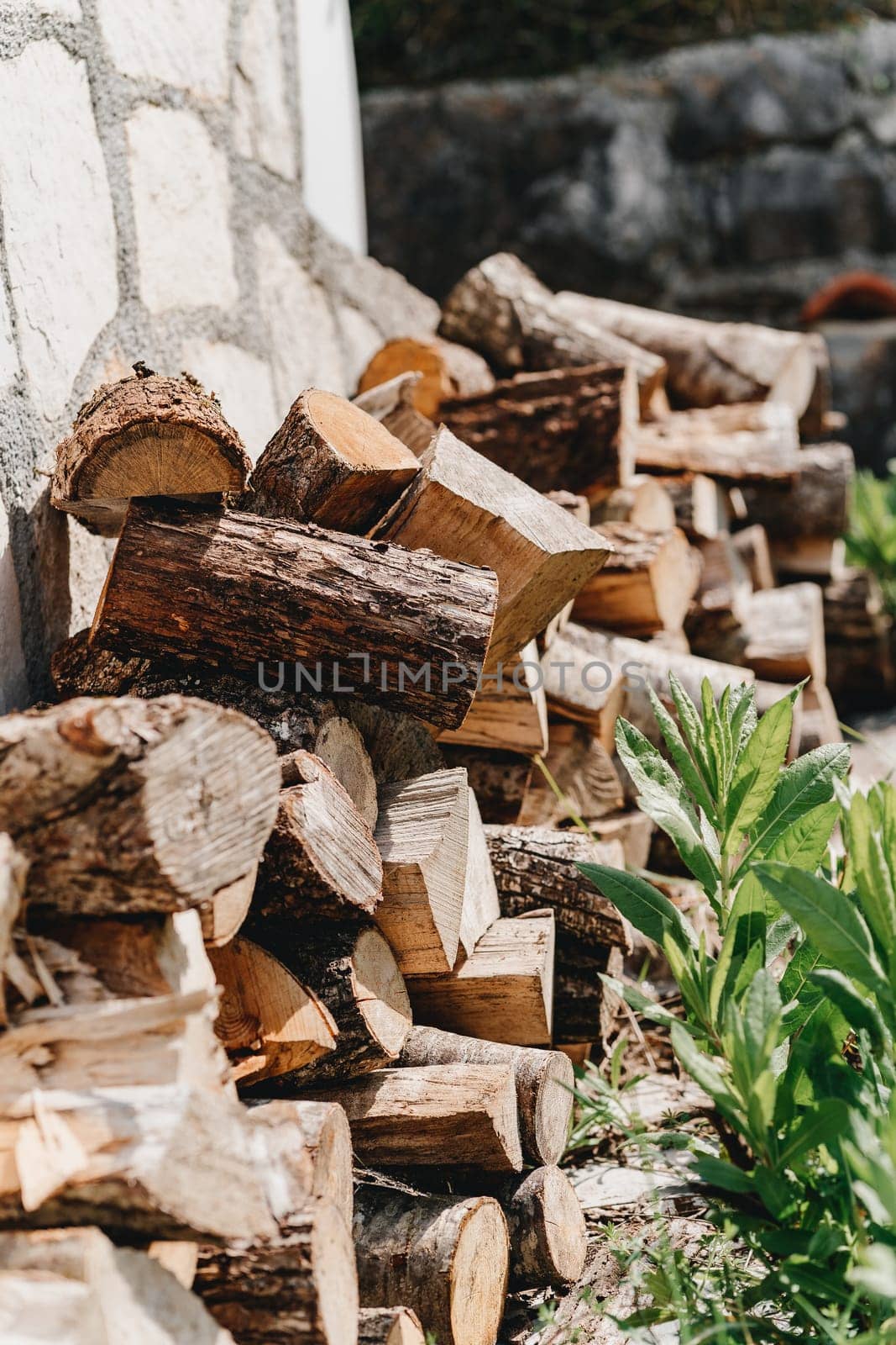 Wood for the fire is lying against the wall. High quality photo