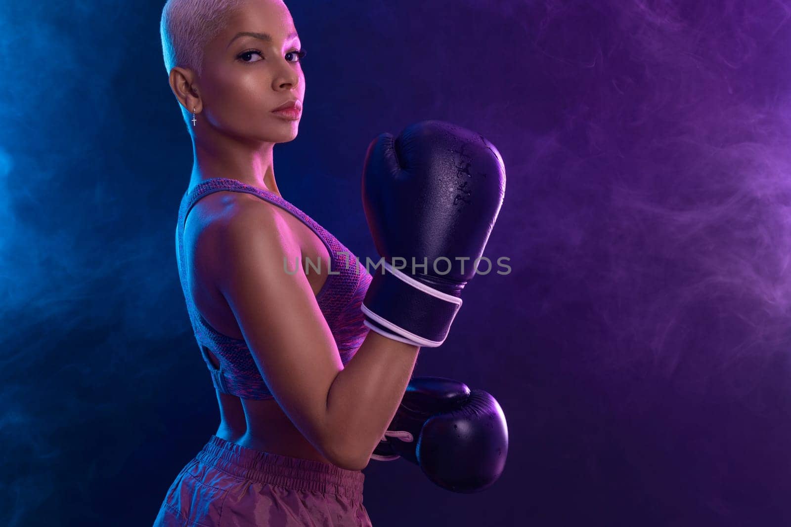 The Boxing. Brazilian woman boxer. Sportsman muay thai boxer fighting in gloves. Isolated on black background. Copy Space. by MikeOrlov