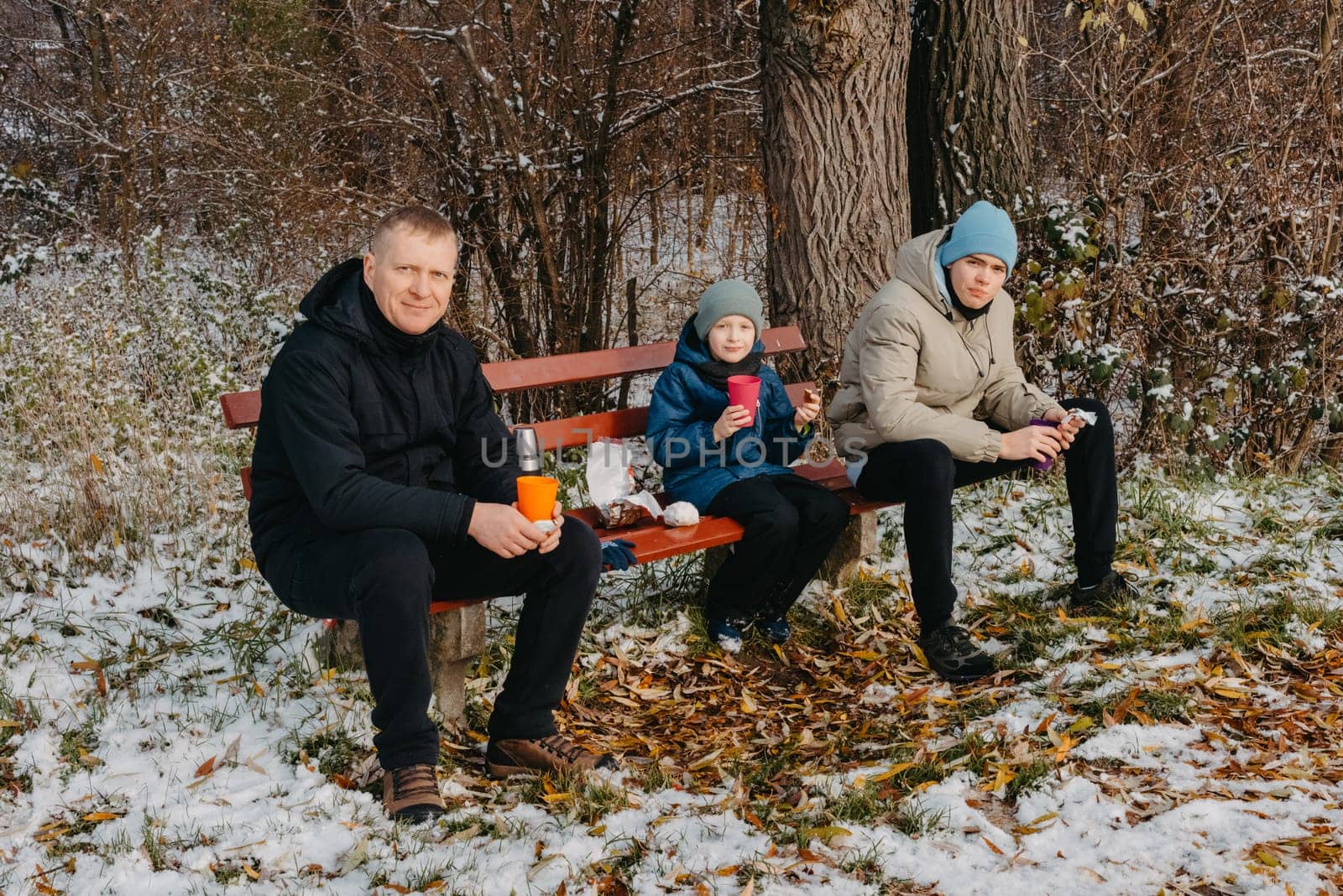 Snowy Park Serenity: Dad and Sons Share Treats and Smiles in a Winter Wonderland. Winter's Togetherness: A Delightful Bench Picnic with Dad and the Boys. A Heartwarming Winter Picnic with Father and Sons in a Snow-Kissed Park by Andrii_Ko