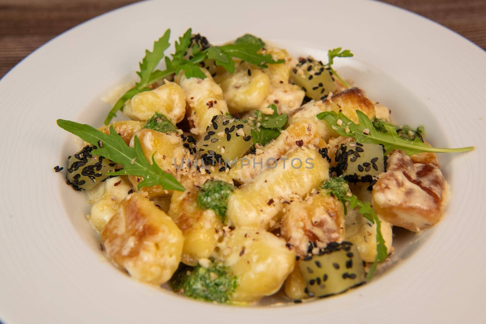 RECIPE FOR POTATO GNOCCHI WITH ROCKET SALAD PESTO AND CREAMY PARMESAN SAUCE. High quality photo