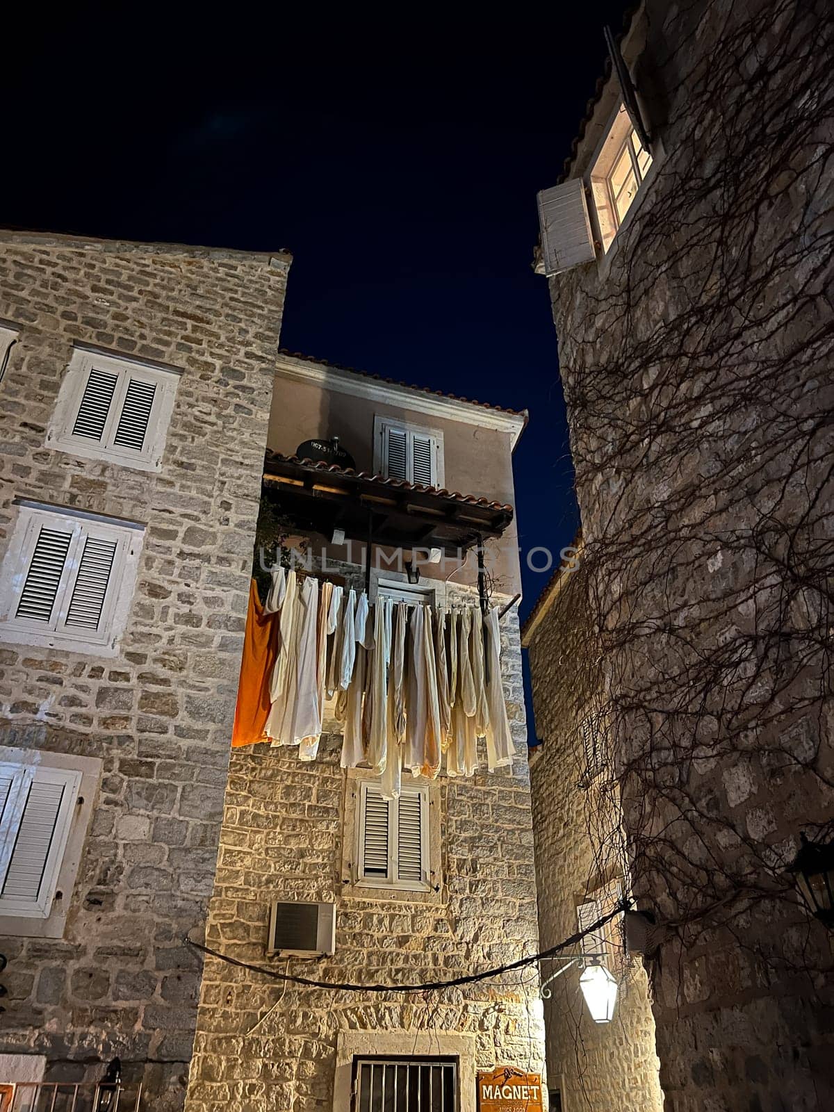 Laundry dries on clothesline between ancient stone houses. High quality photo