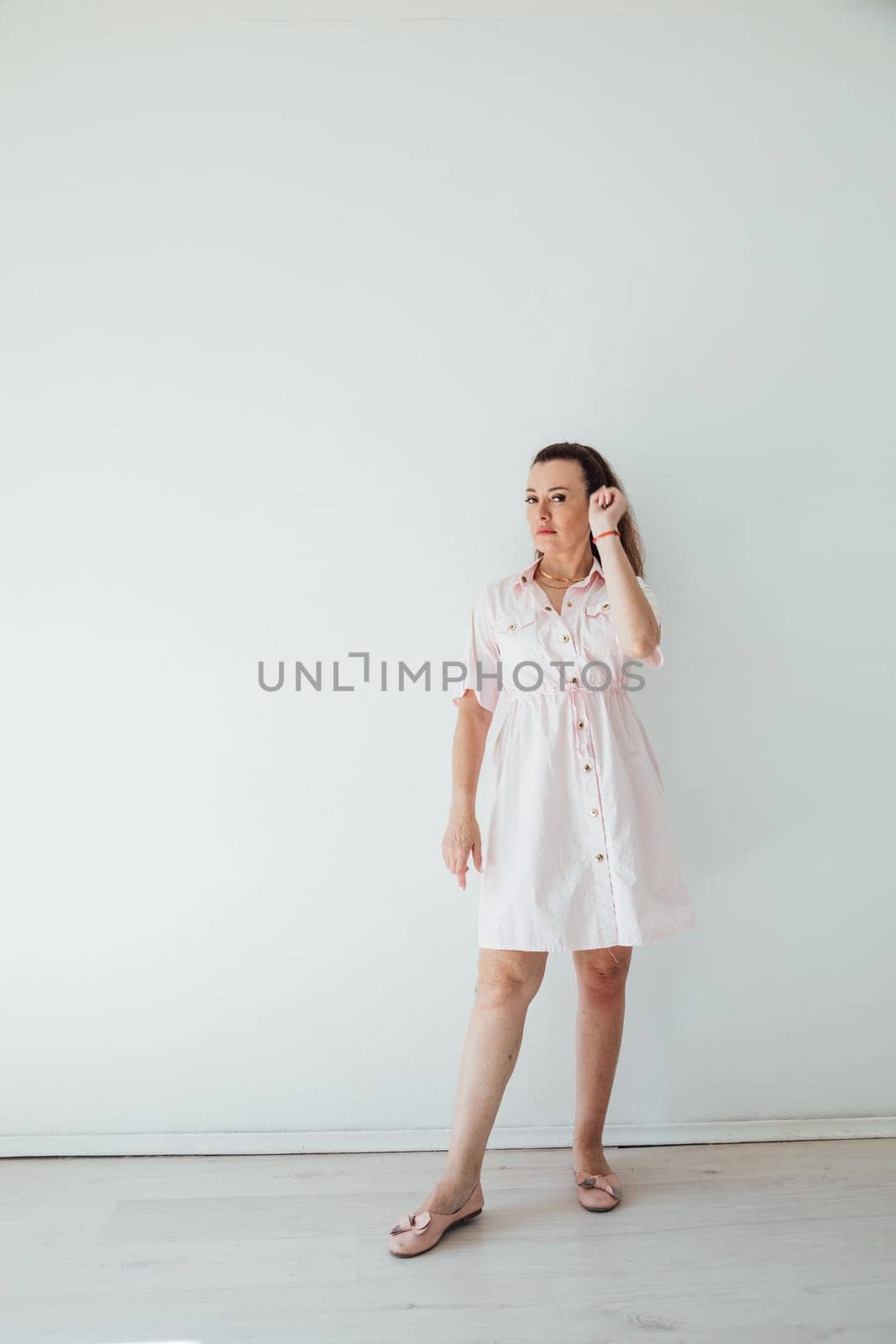 Beautiful brunette woman in summer pink dress smiling