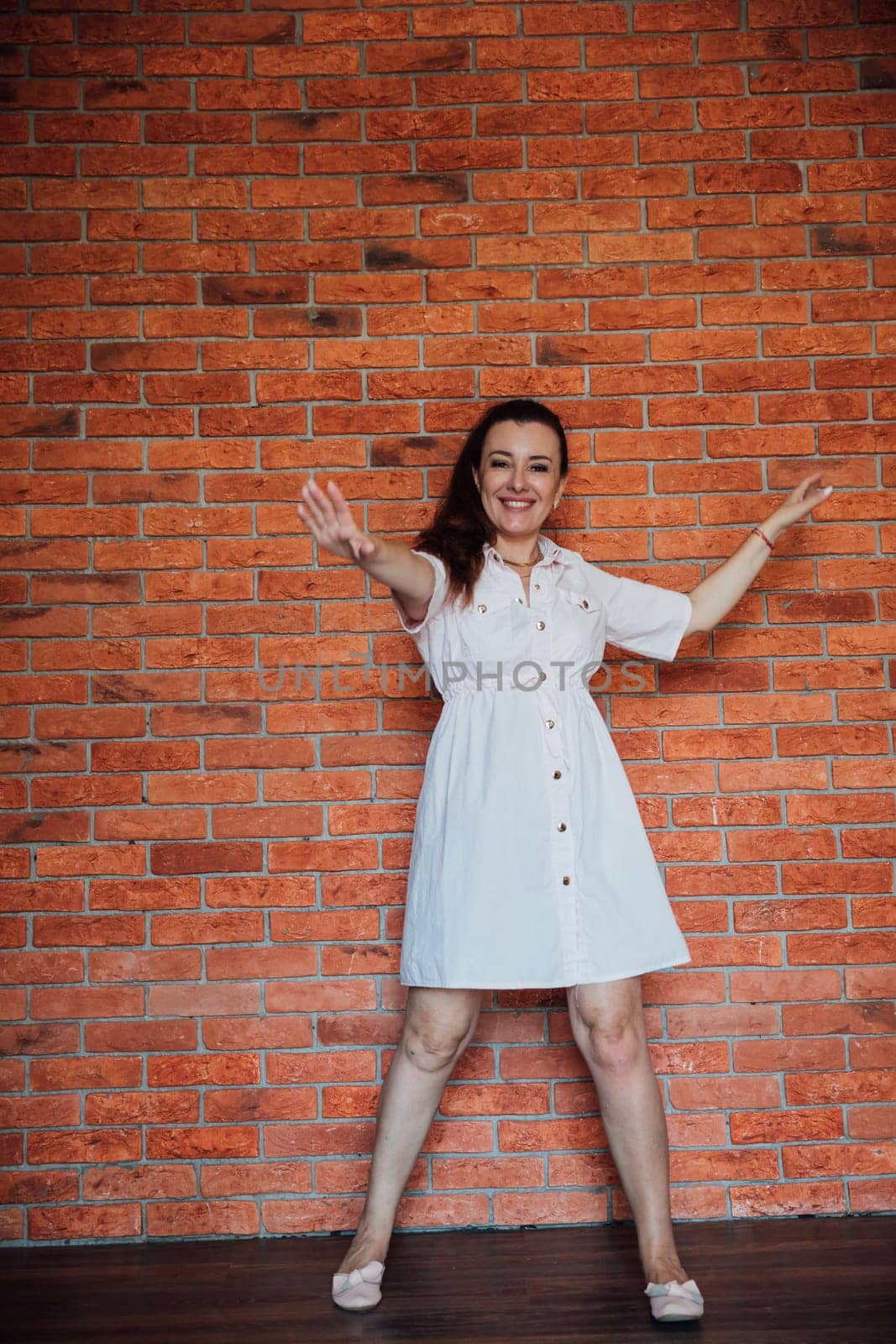 Beautiful brunette woman in summer pink dress smiling