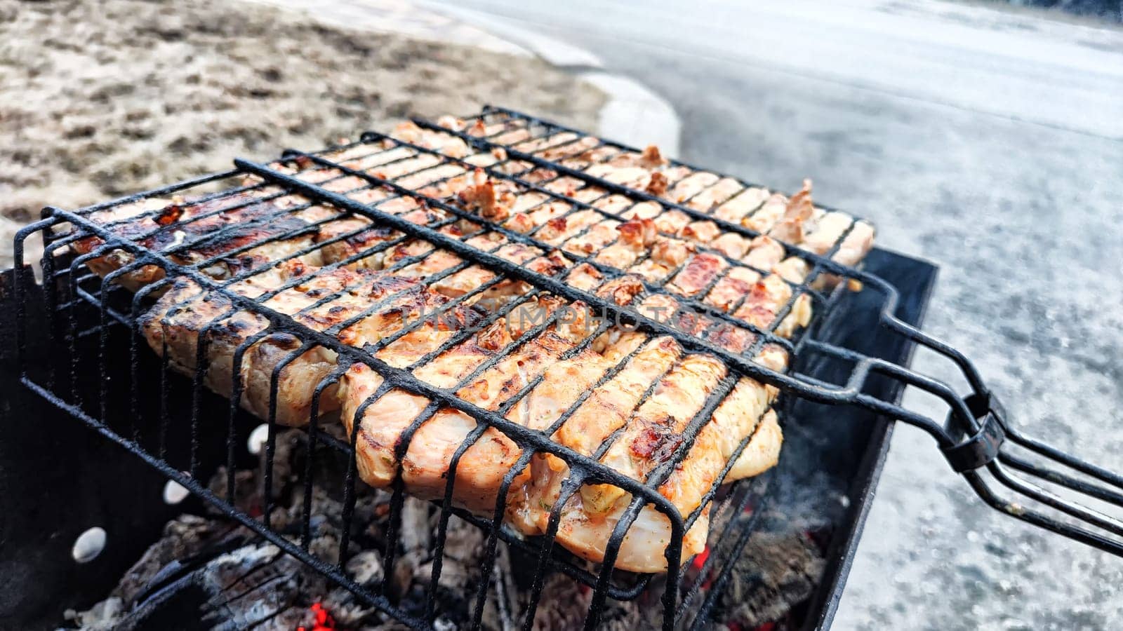Pieces of shish kebab on iron grill over the coals over the grill. Delicious fried meat