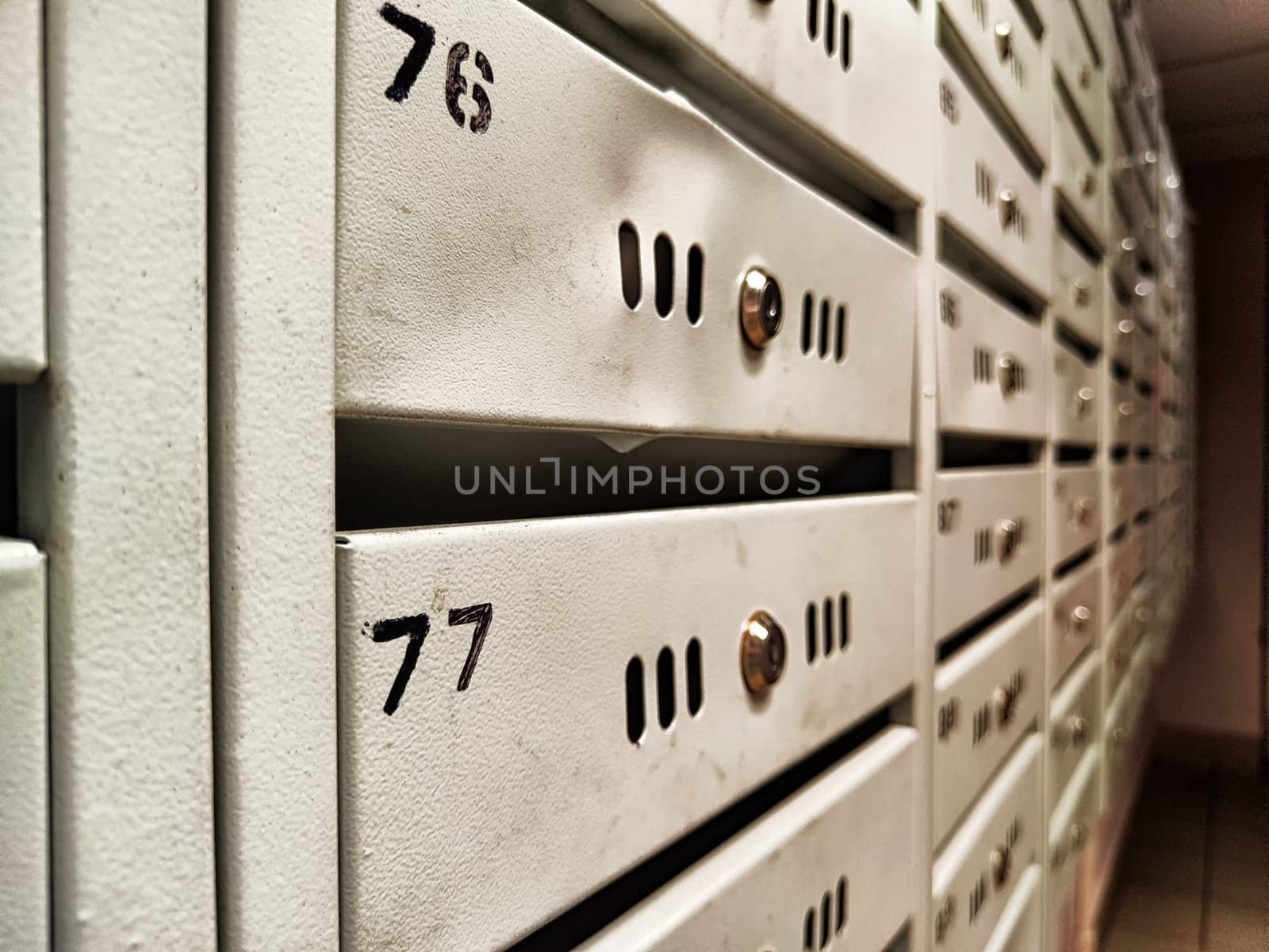 PO Boxes for rent in rows with metallic silver doors and numbers. Background, pattern, repeating rows and frame