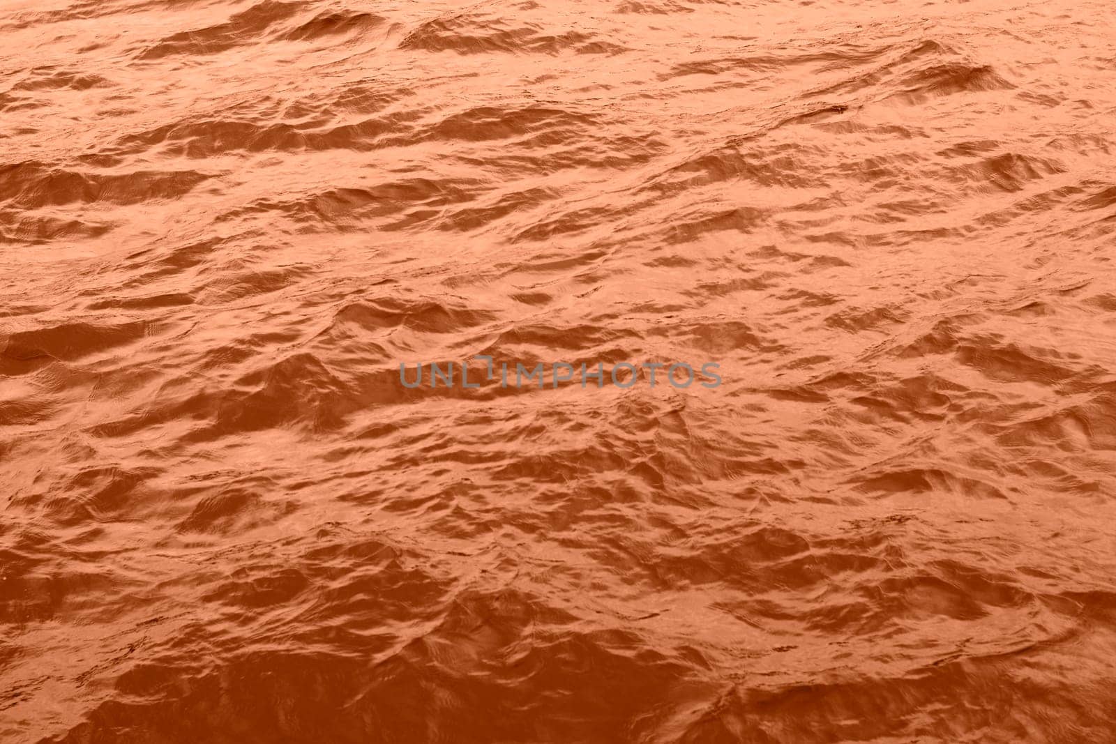 Peach Fuzz toned sea water texture. Pool water with sun reflections. Trendy colour 2024 year. High quality photo