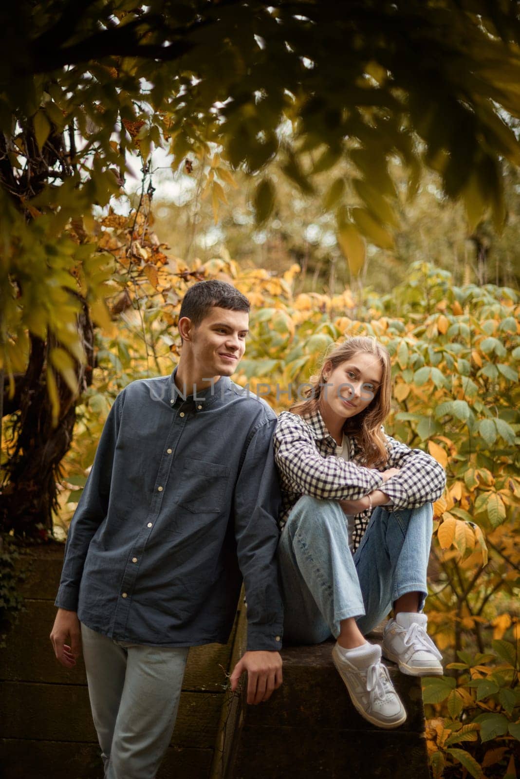 Warm Embrace of Teen Love in the Autumn Park. Capturing Teen Moments: Love Blossoms in Autumn's Embrace. Teenagers in Love: Embracing the Autumn Vibe by Andrii_Ko