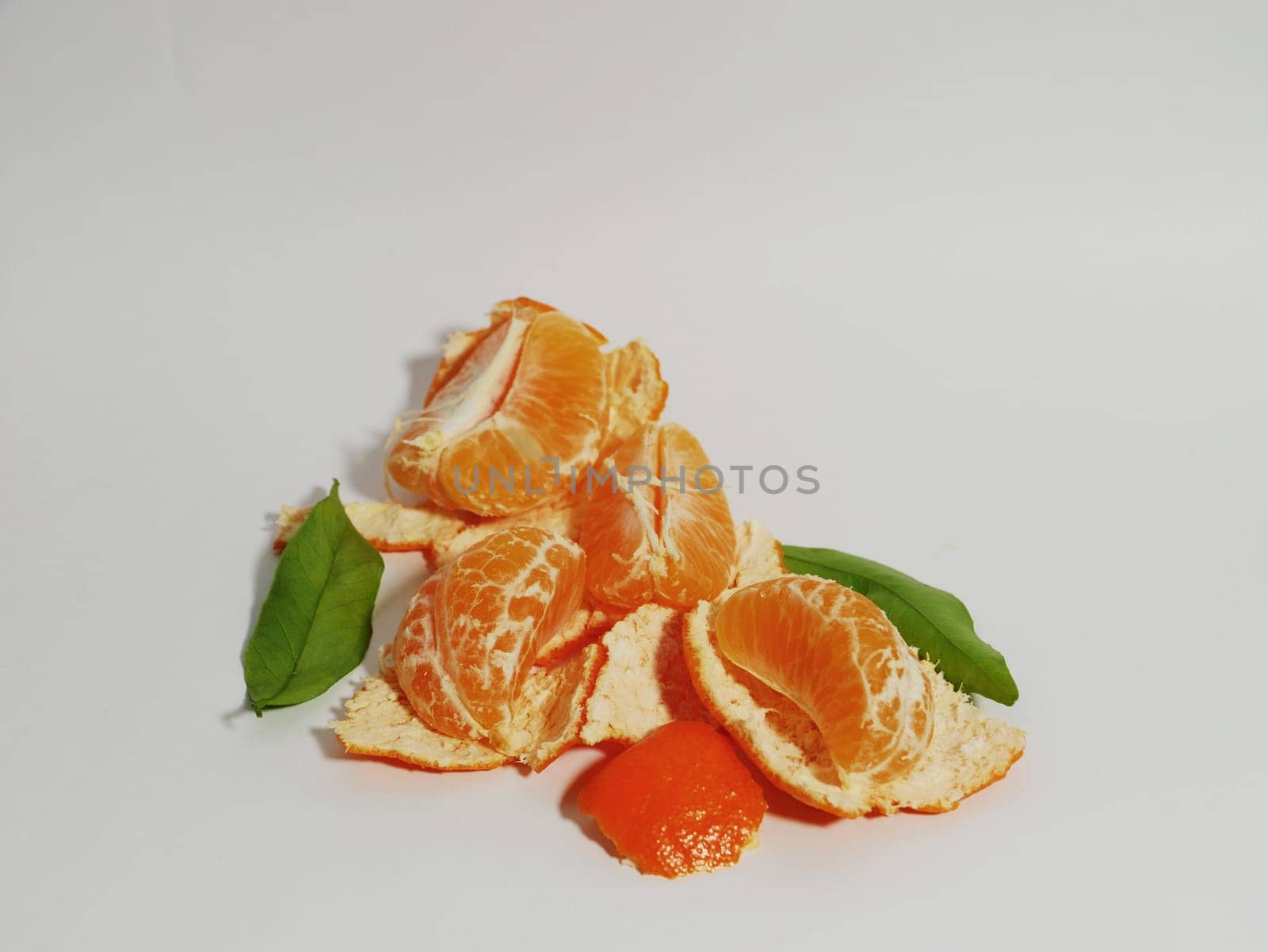 Fresh peeled tangerine and its peel on a white background. by gelog67