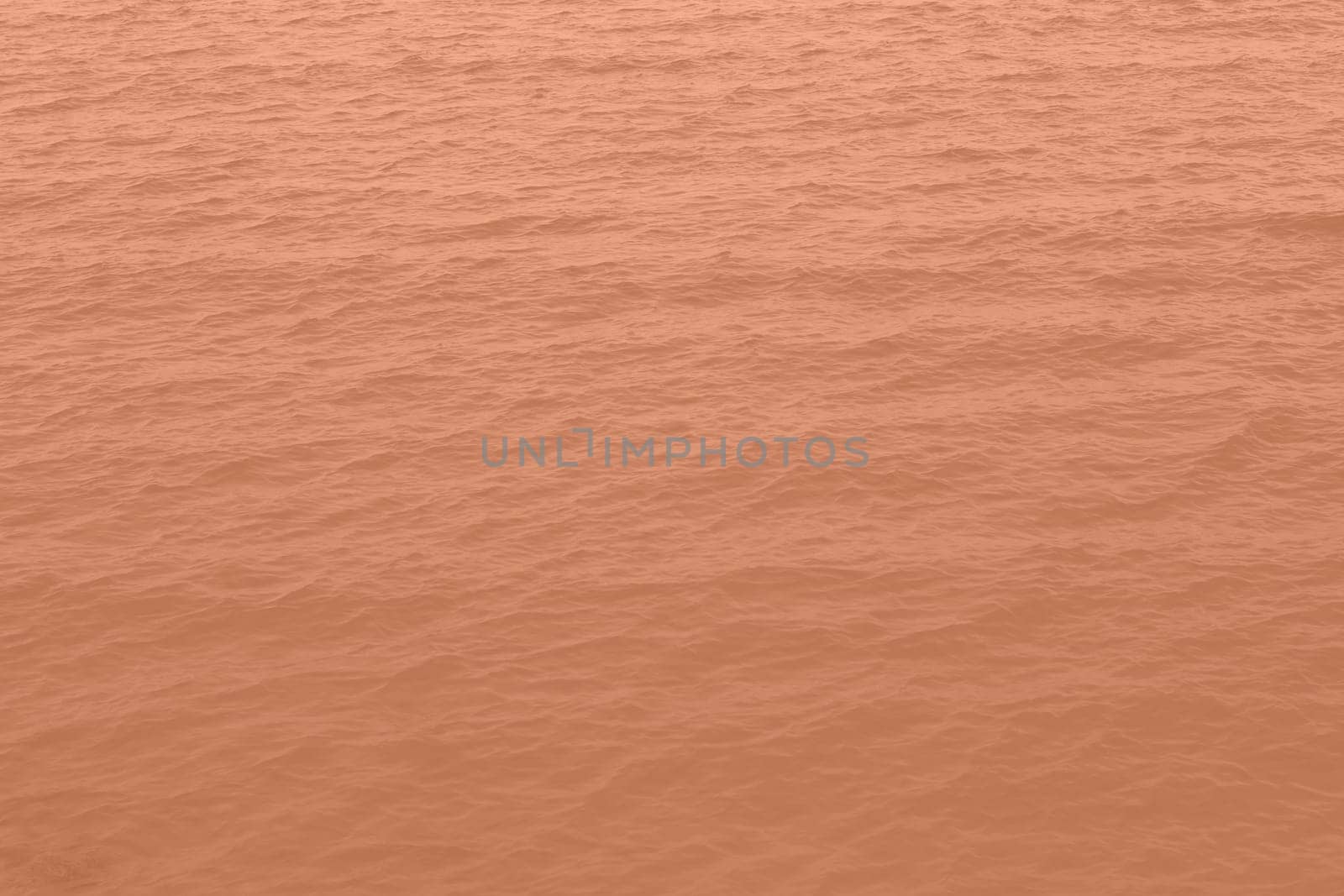 Peach Fuzz toned sea water texture. Pool water with sun reflections. Trendy colour 2024 year. High quality photo