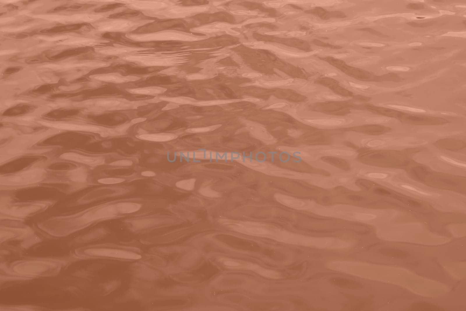 Peach Fuzz toned sea water texture. Pool water with sun reflections. Trendy colour 2024 year. High quality photo