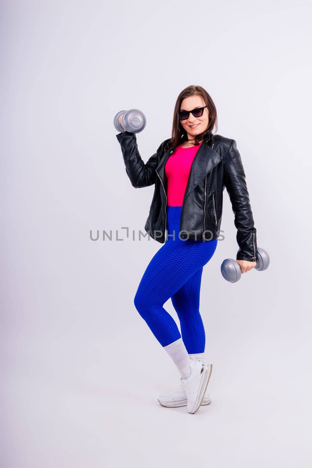 Young smiling happy chubby overweight plus size big fit woman warm up training hold dumbbells