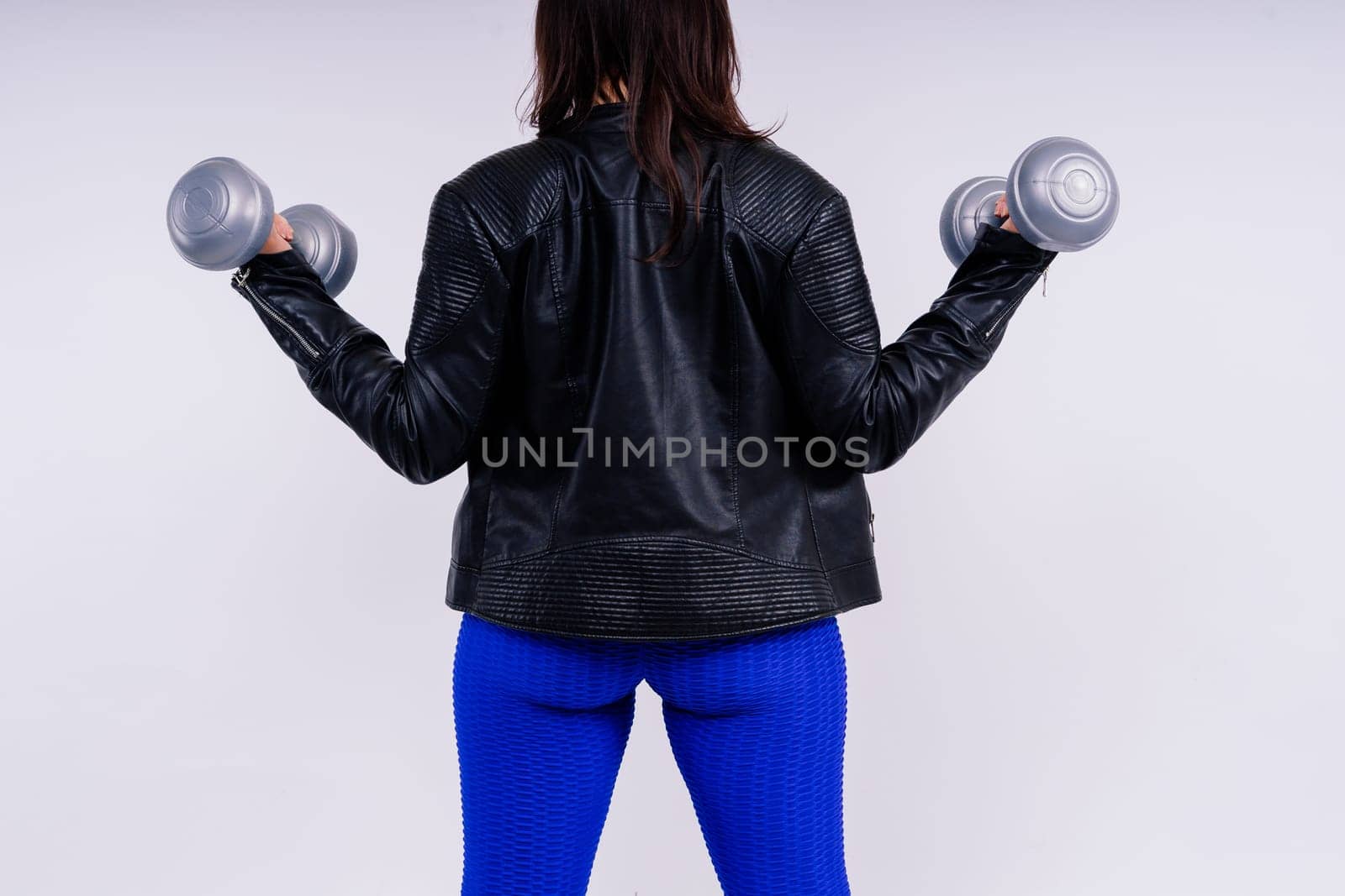 Young smiling happy chubby overweight plus size big fit woman warm up training hold dumbbells