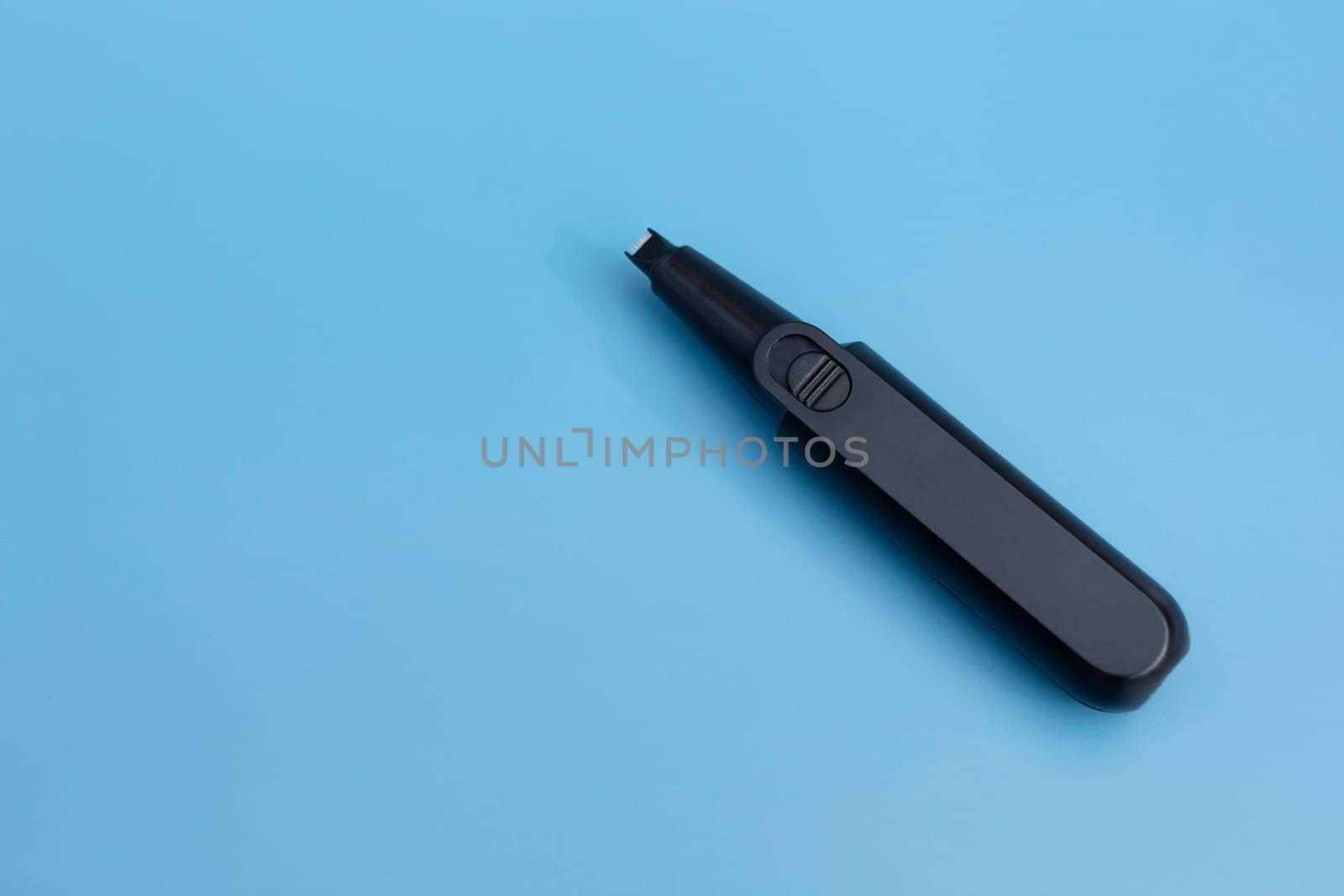 Mockup Nose Razor On Blue Background, Flatly. Compact Electric Nose And Ear Hair Trimmer, Facial Shaver. Nose And Ear Hair Removal Tool, Space For Text. Horizontal Plane by netatsi