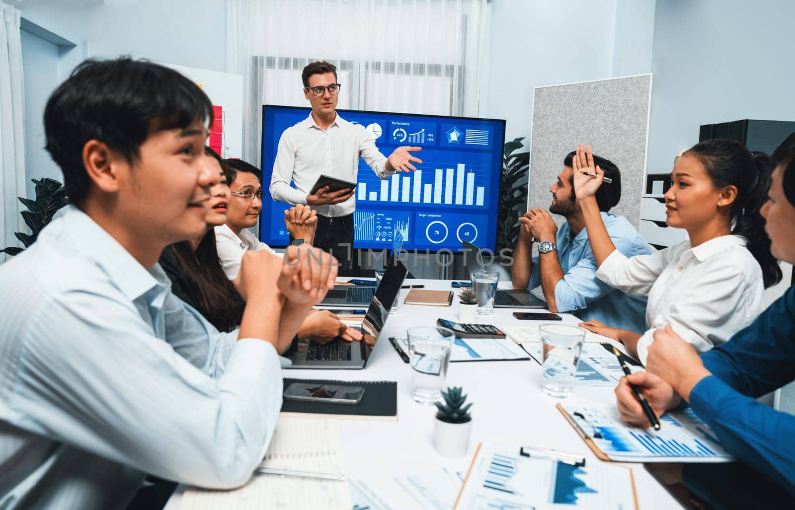 Presentation in office or meeting room with analyst team utilizing BI Fintech to analyze financial data. Businesspeople analyzing BI dashboard power display on TV screen for strategic planning.Prudent