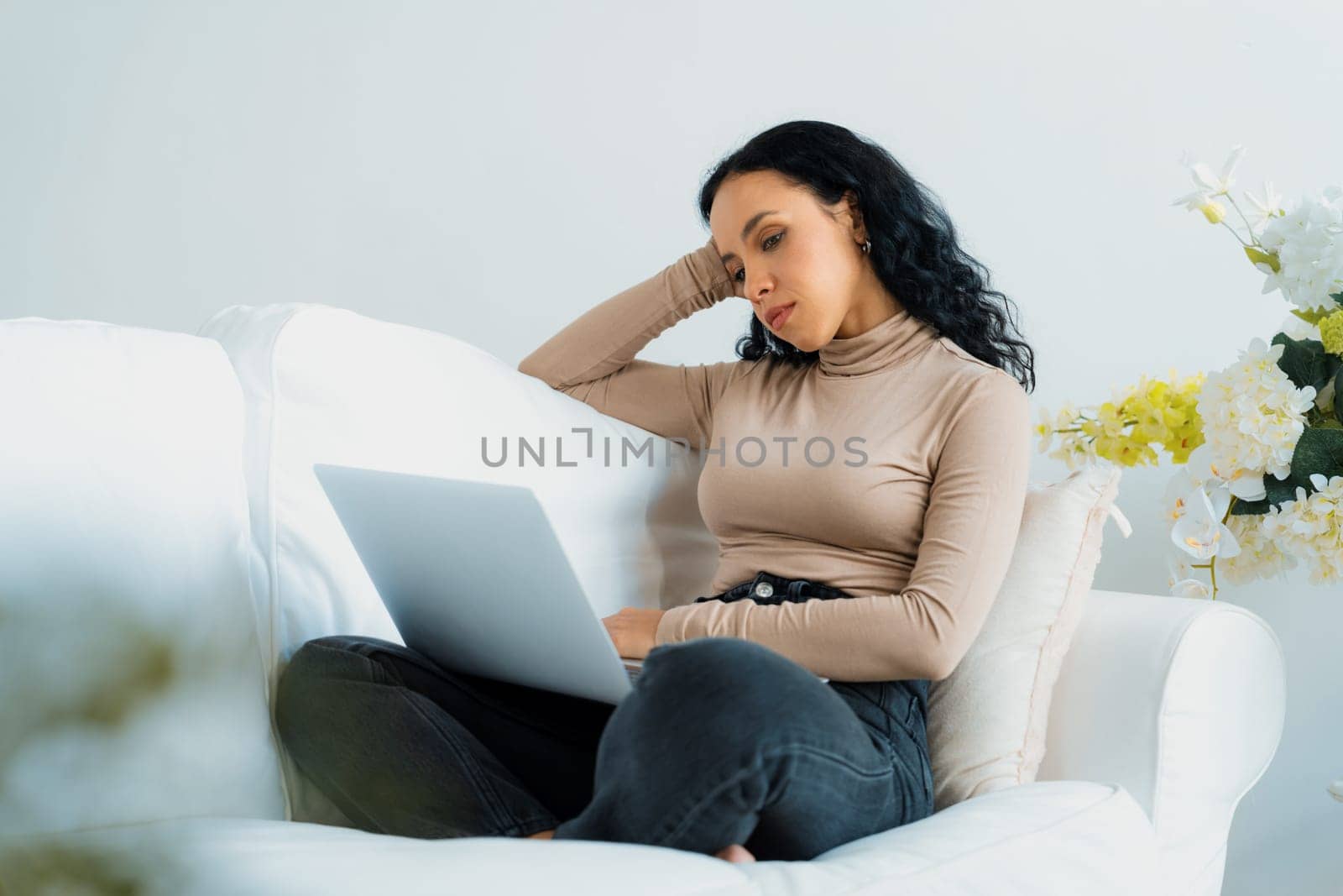 Young woman feels depressed while looking at crucial work in laptop computer by biancoblue