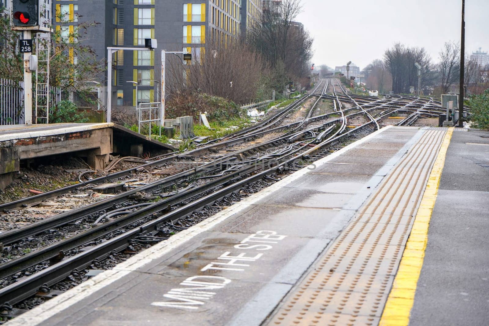 End of platform on train station at London, Mind the step written down, many railway crossings in distance by Ivanko