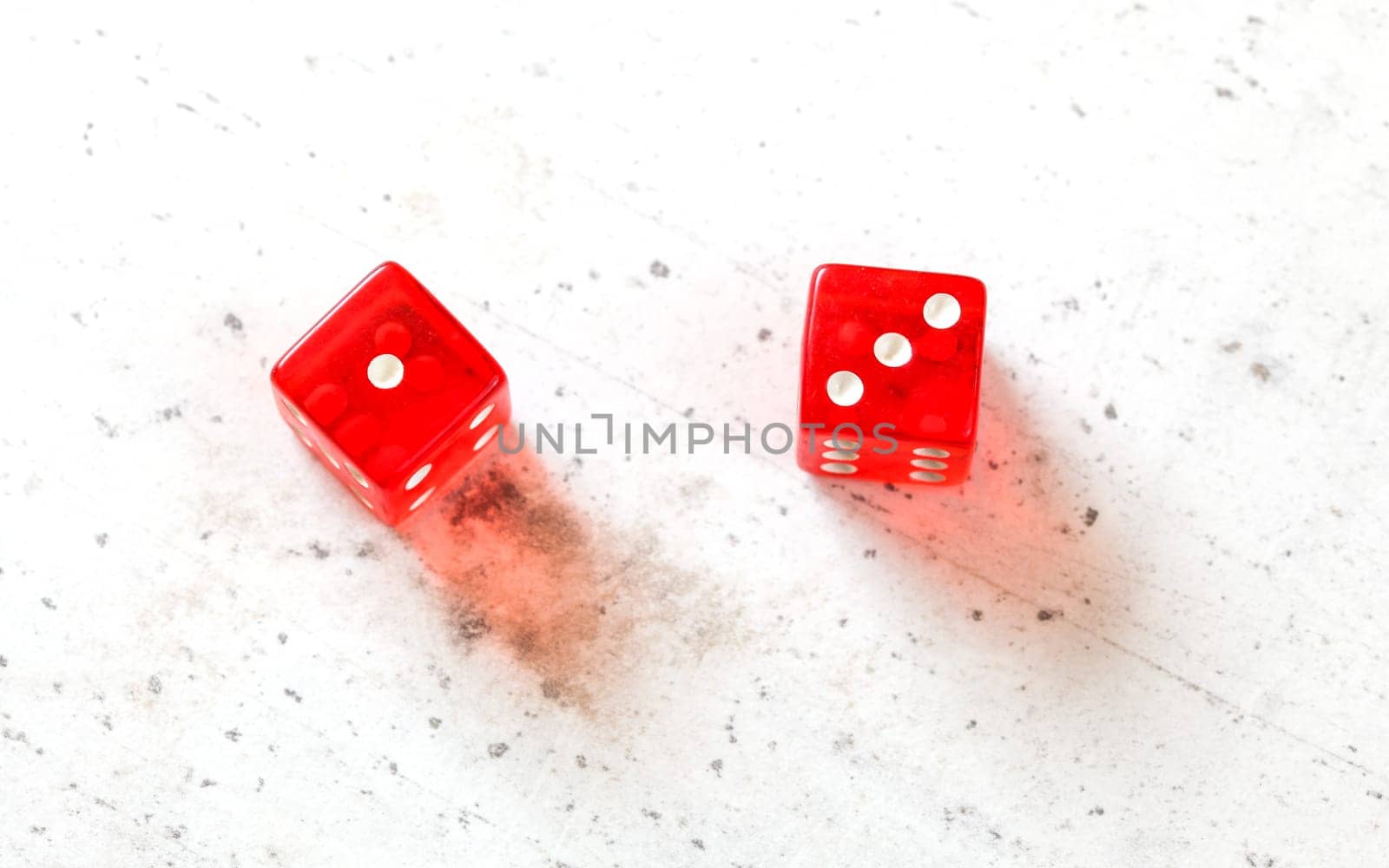 Two red craps dices showing Easy Four (number 1 and 3) overhead shot on white board