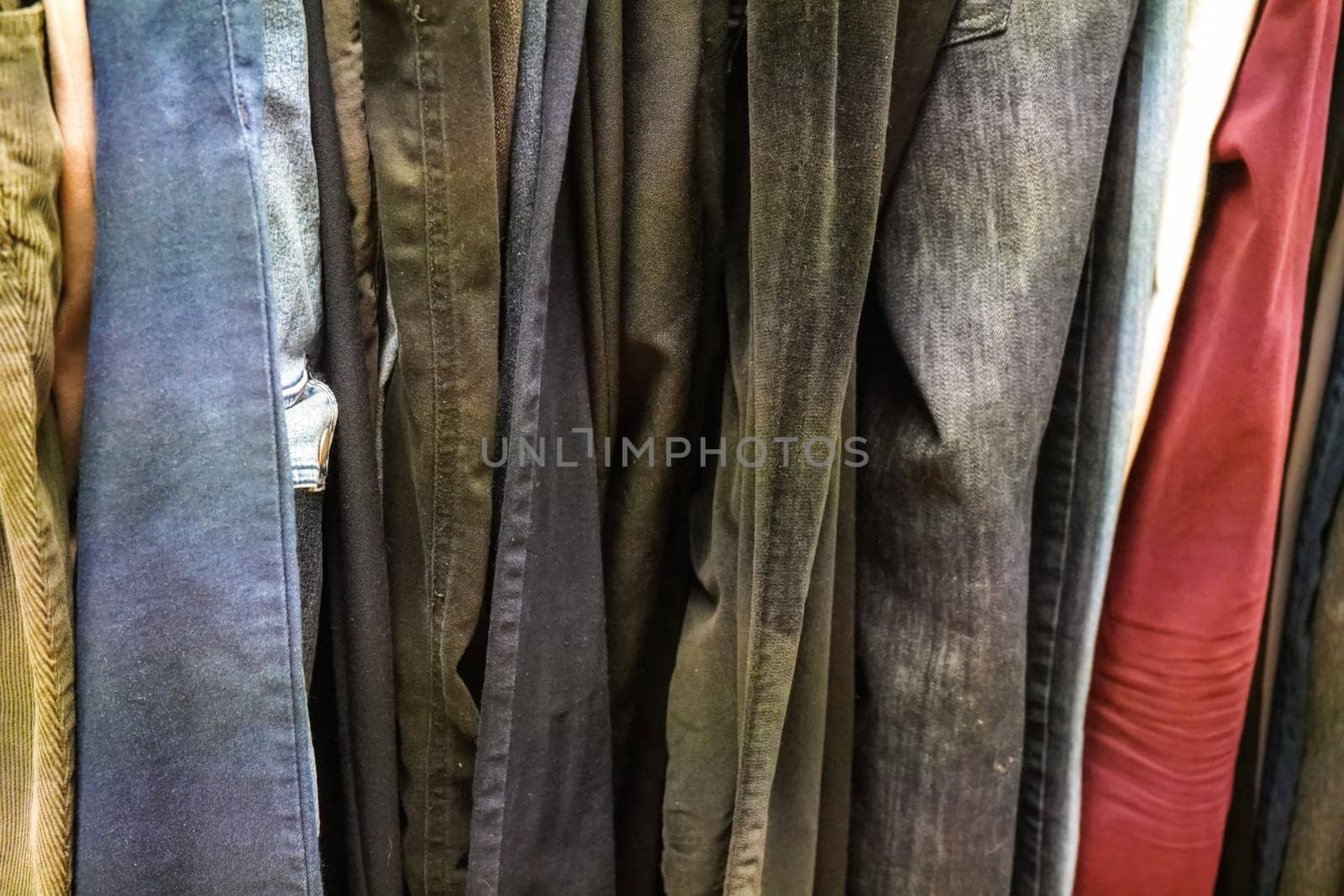 Closeup of old Jeans and trousers displayed at thrift shop by Ivanko