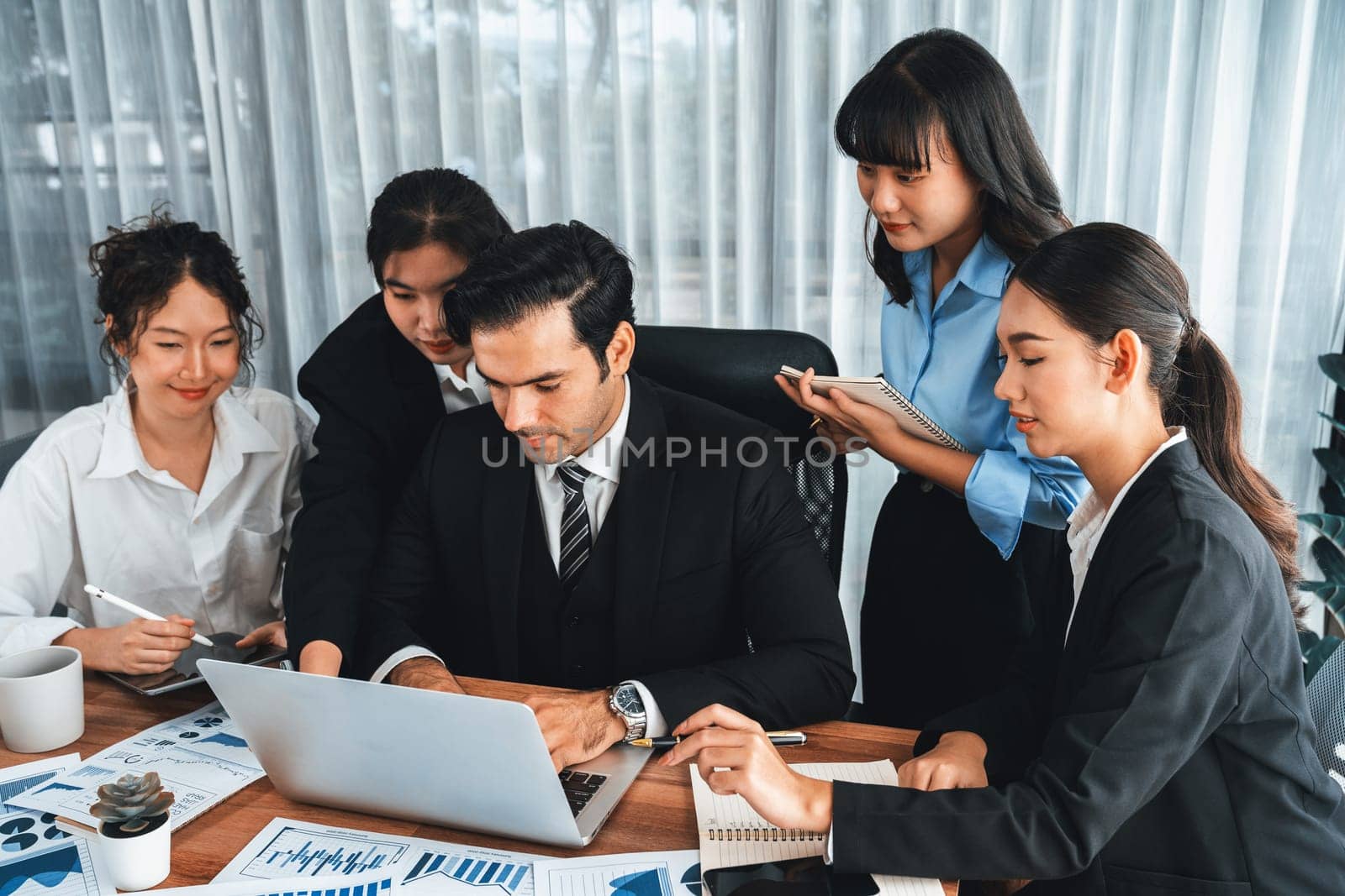 Diverse group of business analyst team analyzing financial data report paper on office table. Chart and graph dashboard by business intelligence analysis for strategic marketing planning Meticulous