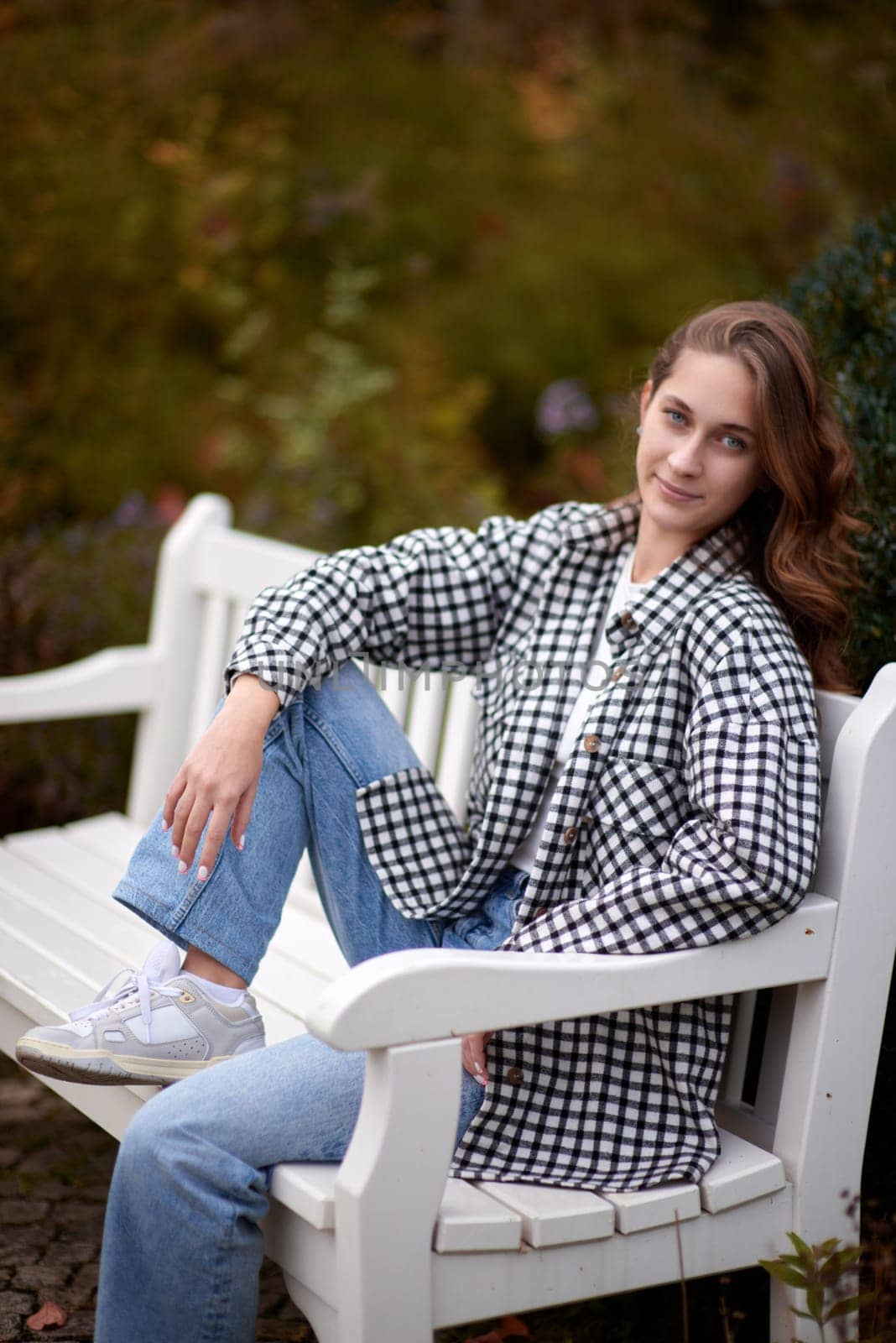 Charming Autumn Casual: Beautiful Girl on Park Bench. Autumn Grace: Stylish Casual Amidst Fall Foliage. Casual Chic in Autumn: Beauty on a Park Bench by Andrii_Ko