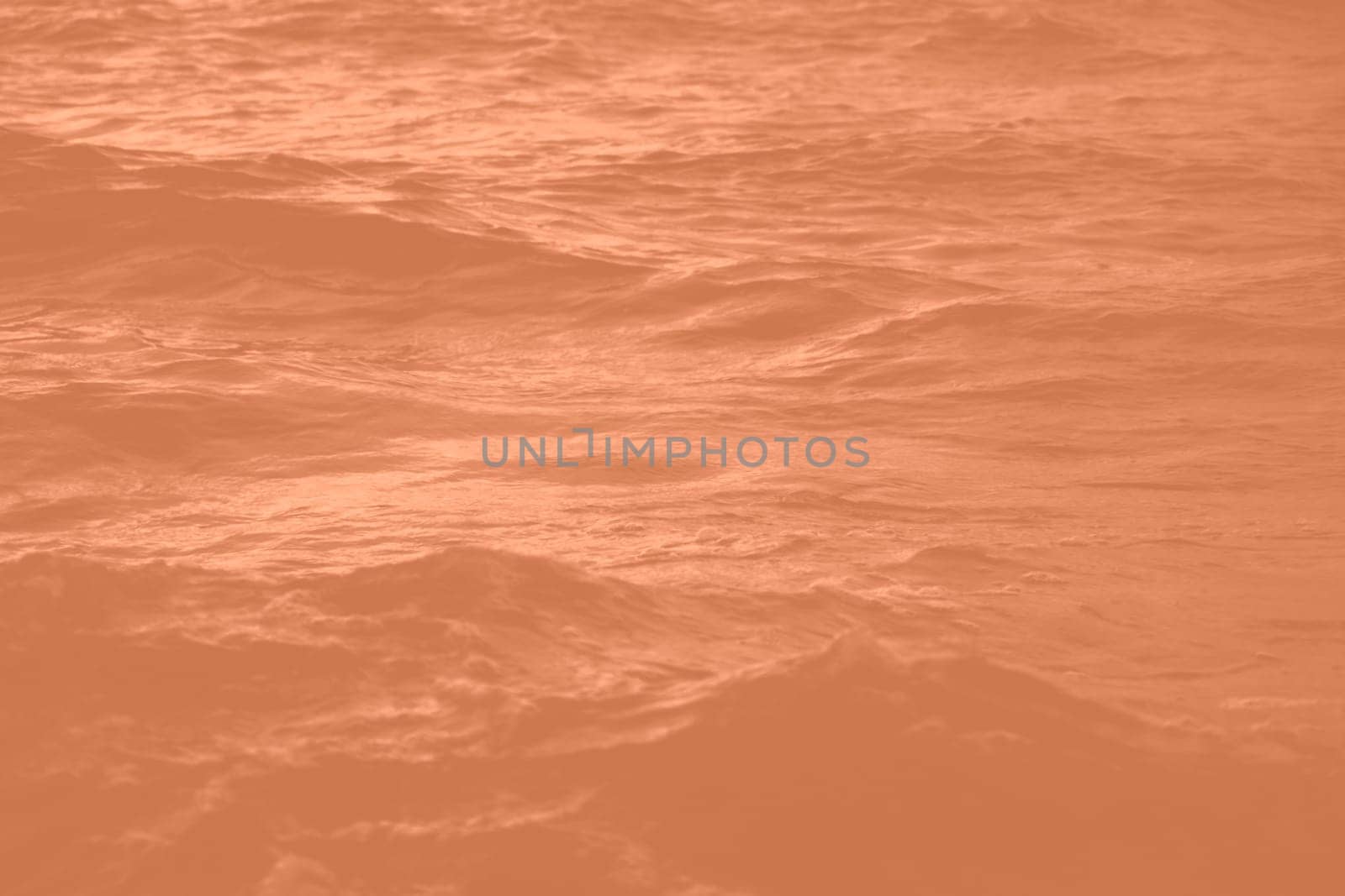 Peach Fuzz toned sea water texture. Pool water with sun reflections. Trendy colour 2024 year. High quality photo