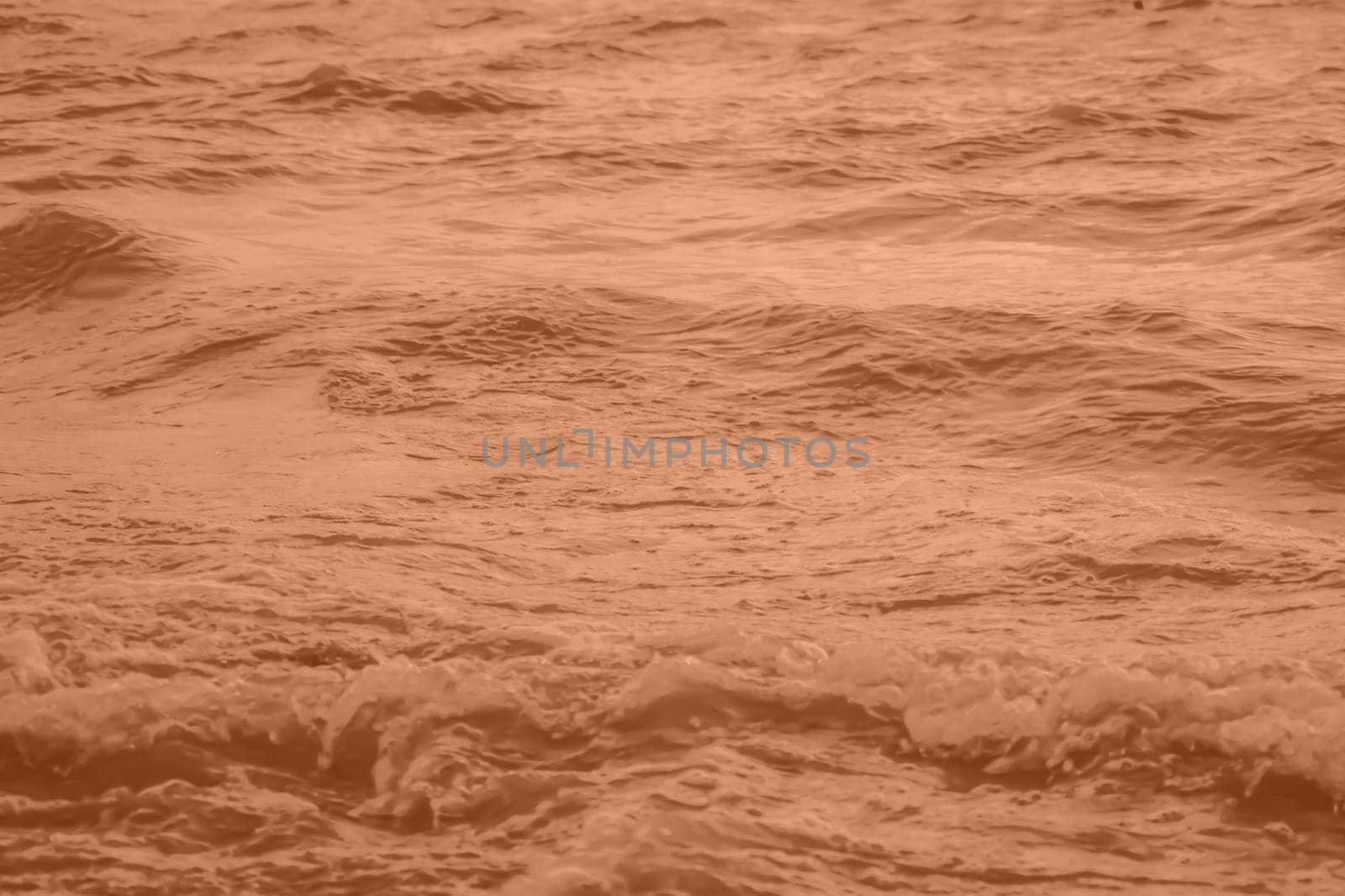 Peach Fuzz toned sea water texture. Pool water with sun reflections. Trendy colour 2024 year. High quality photo