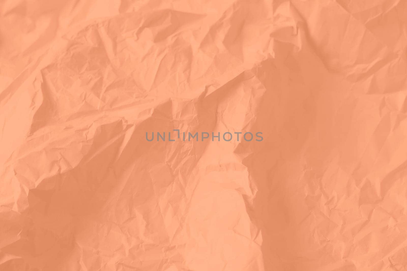 Crumpled paper Peach Fuzz color of the year 2024. Texture crumpled paper for your design. Copy space. High quality photo