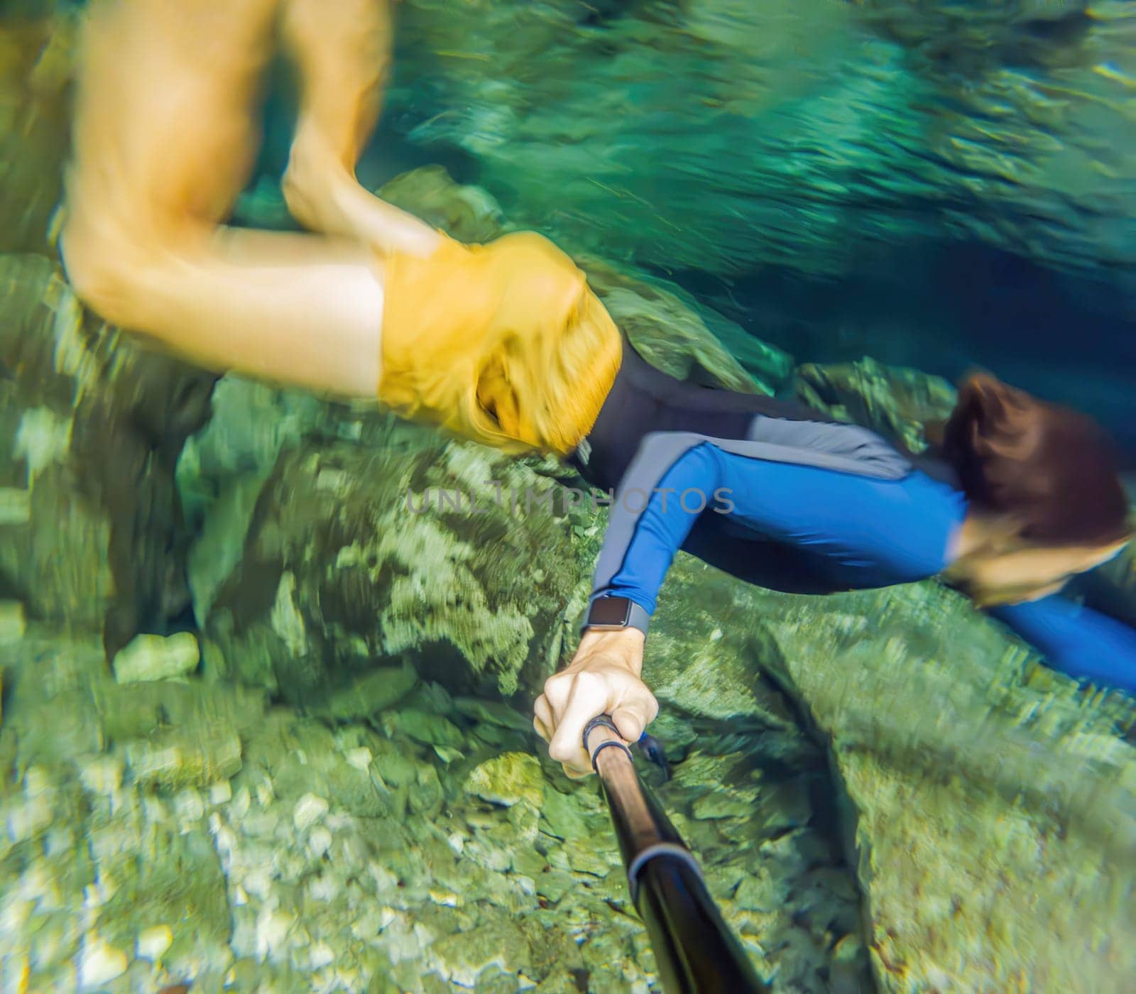 Man immersed in the enchanting beauty of a Mexican cenote, surrounded by crystal-clear waters and captivating natural formations.