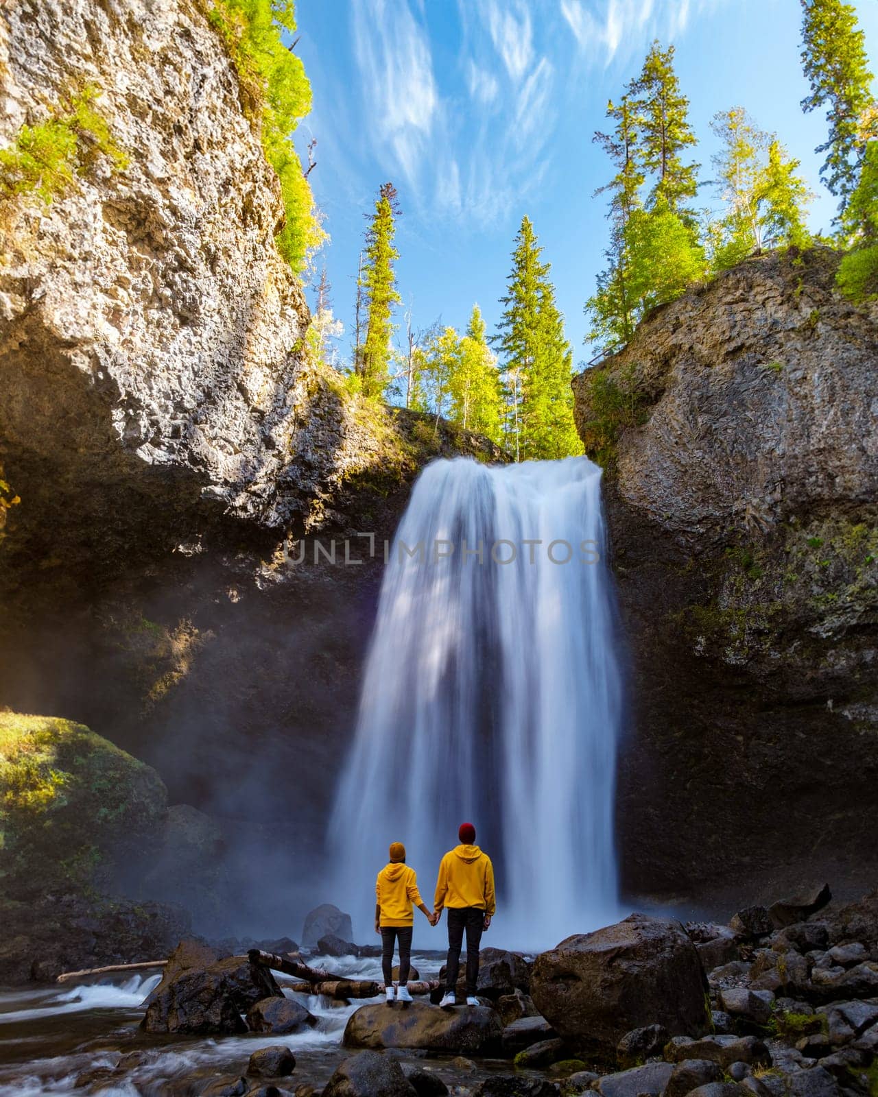 Moul Falls Canada a Beautiful waterfall in Canada British Columbia, a couple of men and a woman visit Moul Falls, the most famous waterfall in Wells Gray Provincial Park.