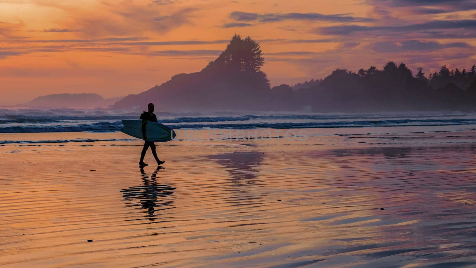 Tofino beach Vancouver Island Pacific rim coast during sunset, surfers with surfboard during sunset at the beach, surfers silhouette Canada Vancouver Island Tofino Long beach