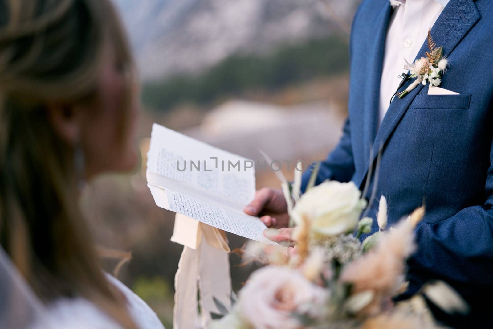 Groom reads the oath to the bride from a piece of paper. High quality photo