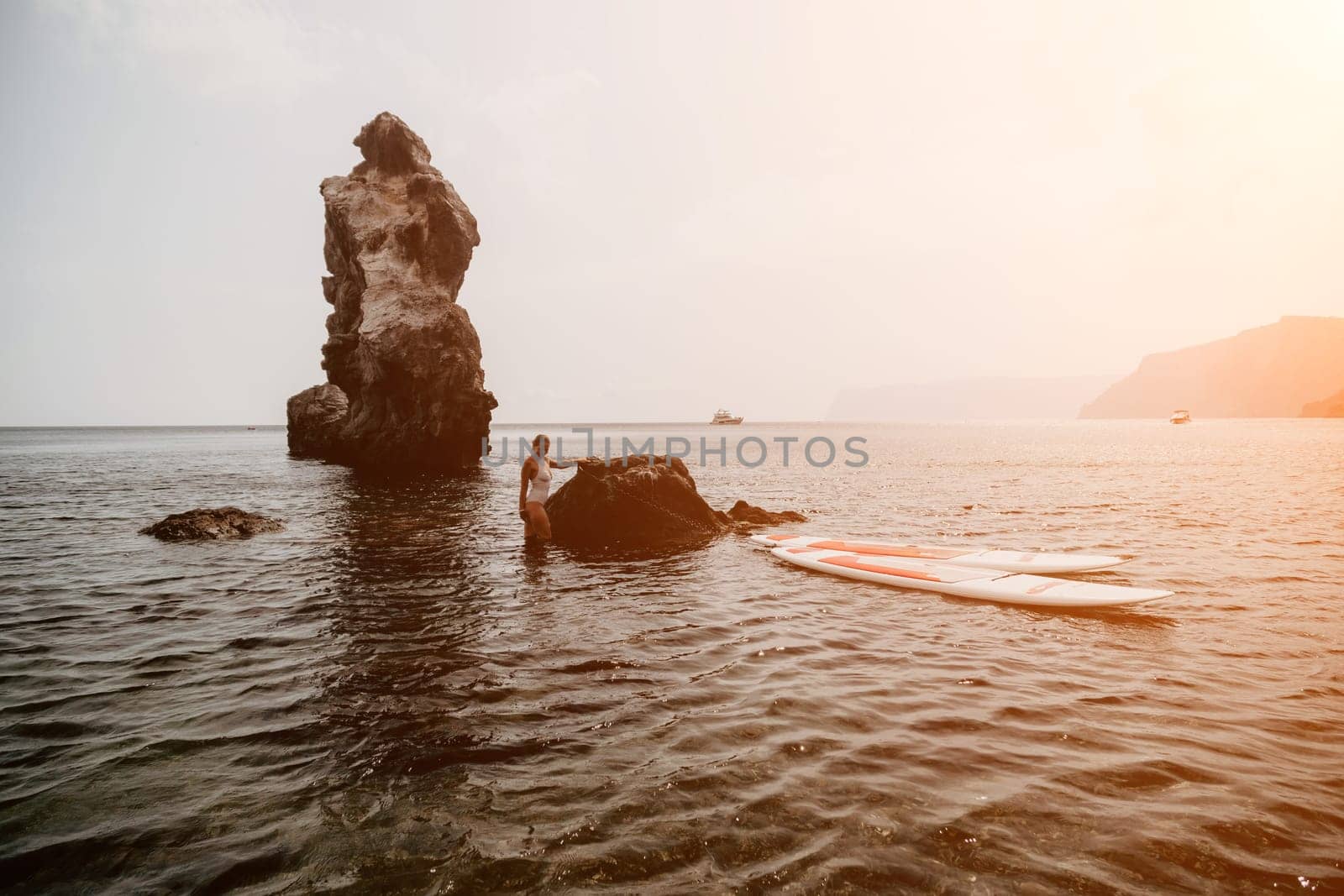 Woman sup yoga. Middle age sporty woman practising yoga pilates on paddle sup surfboard. Female stretching doing workout on sea water. Modern individual hipster outdoor summer sport activity