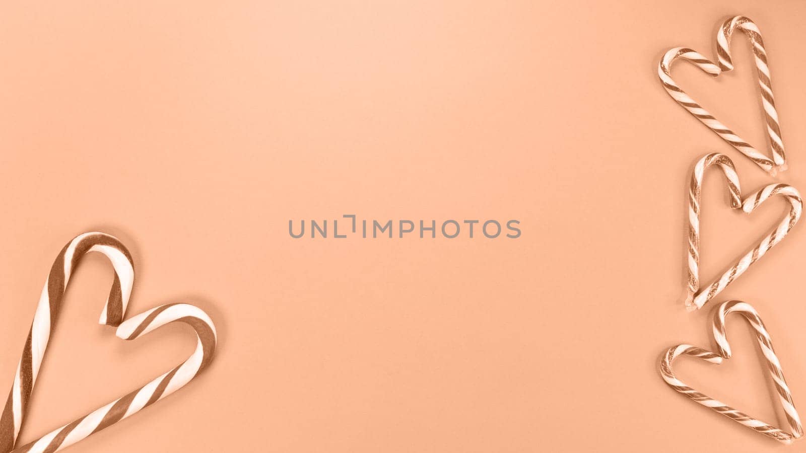 Heart shaped with Candy cane sweets. Image toned in Peach Fuzz color of the year 2024. St Valentine Day, Love