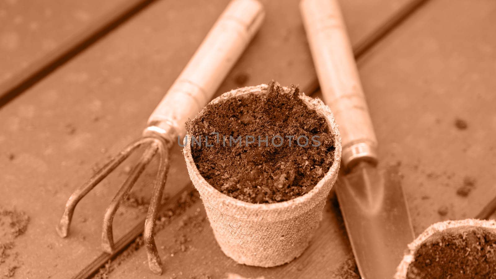Eco friendly biodegradable peat pots and garden tools. Image toned in Peach Fuzz color of the year 2024. Spring natural gardening, eco, plant care, organic product.