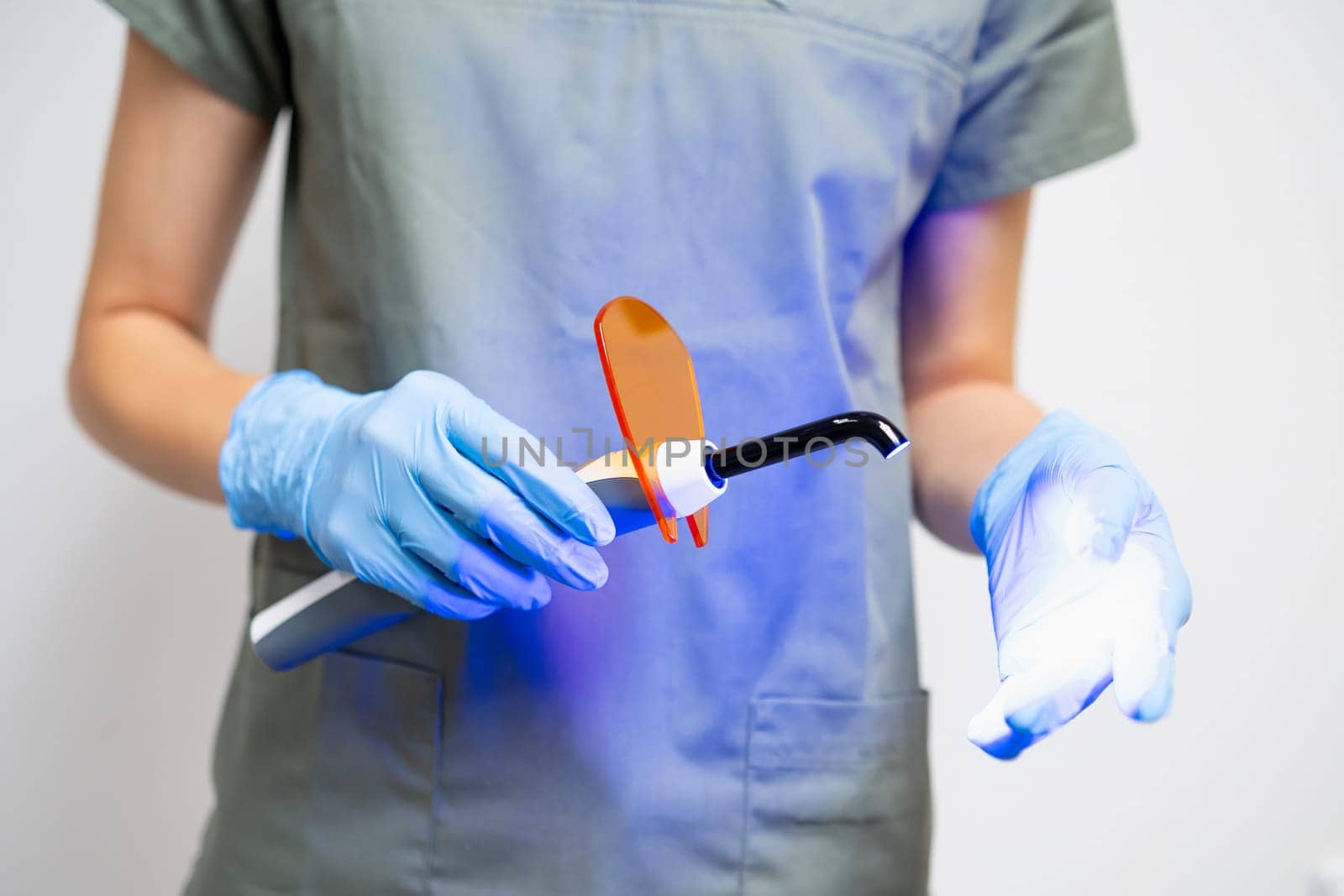 UV lamp in dentists hand in rubber gloves. by vladimka