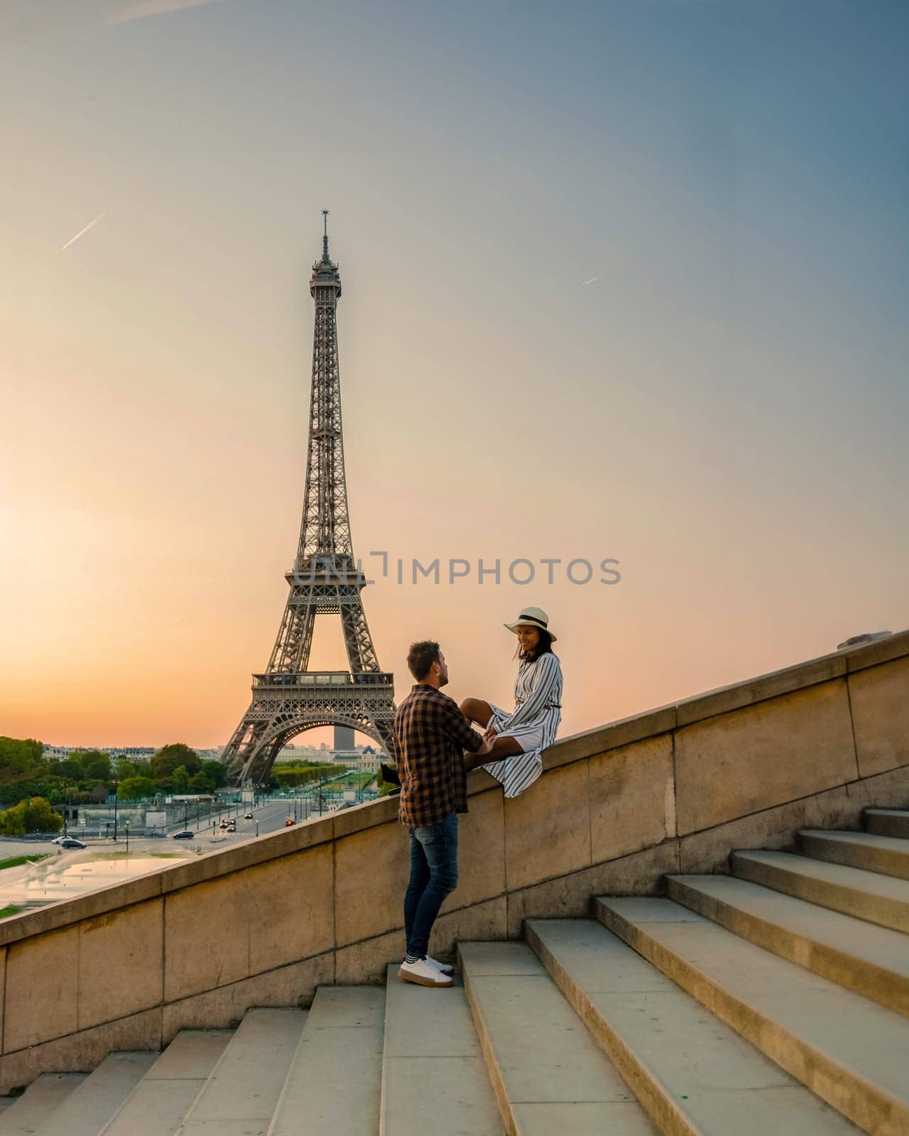 Young couple by Eiffel tower at Sunrise, Paris Eifel tower Sunrise man woman in love, valentine concept in Paris the city of love. Men and women visiting Eiffel tower by fokkebok