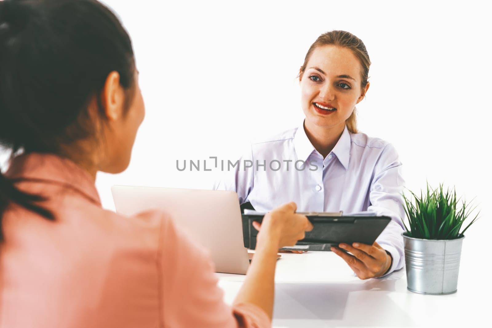 Two young business women in meeting at office table for job application and business agreement. Recruitment and human resources concept. uds