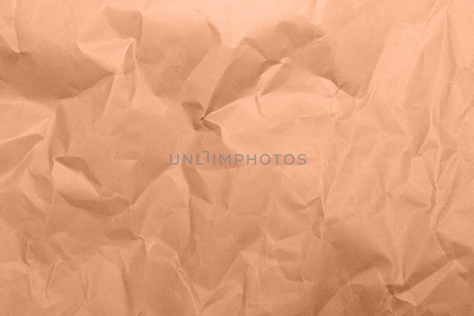 Peach fuzz, color of the year 2024, shining luxurious fabric. Wrinkled paper texture. Copy space for text