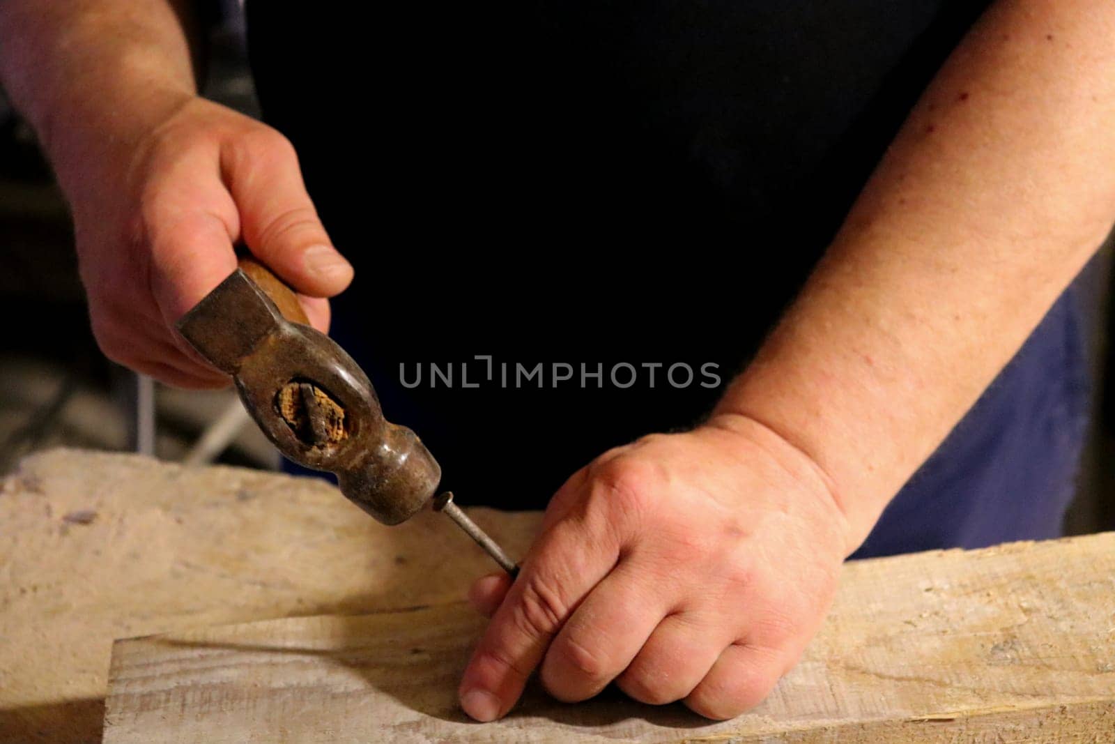 Hands with a tool on the background of a carpentry workshop. Photo in high quality.