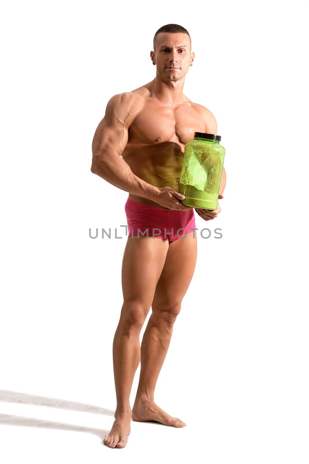 Young handsome male bodybuilder holding protein container by artofphoto