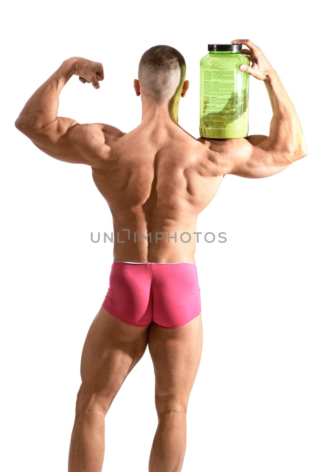 Young handsome male bodybuilder holding protein container, isolated on white, seen from behind