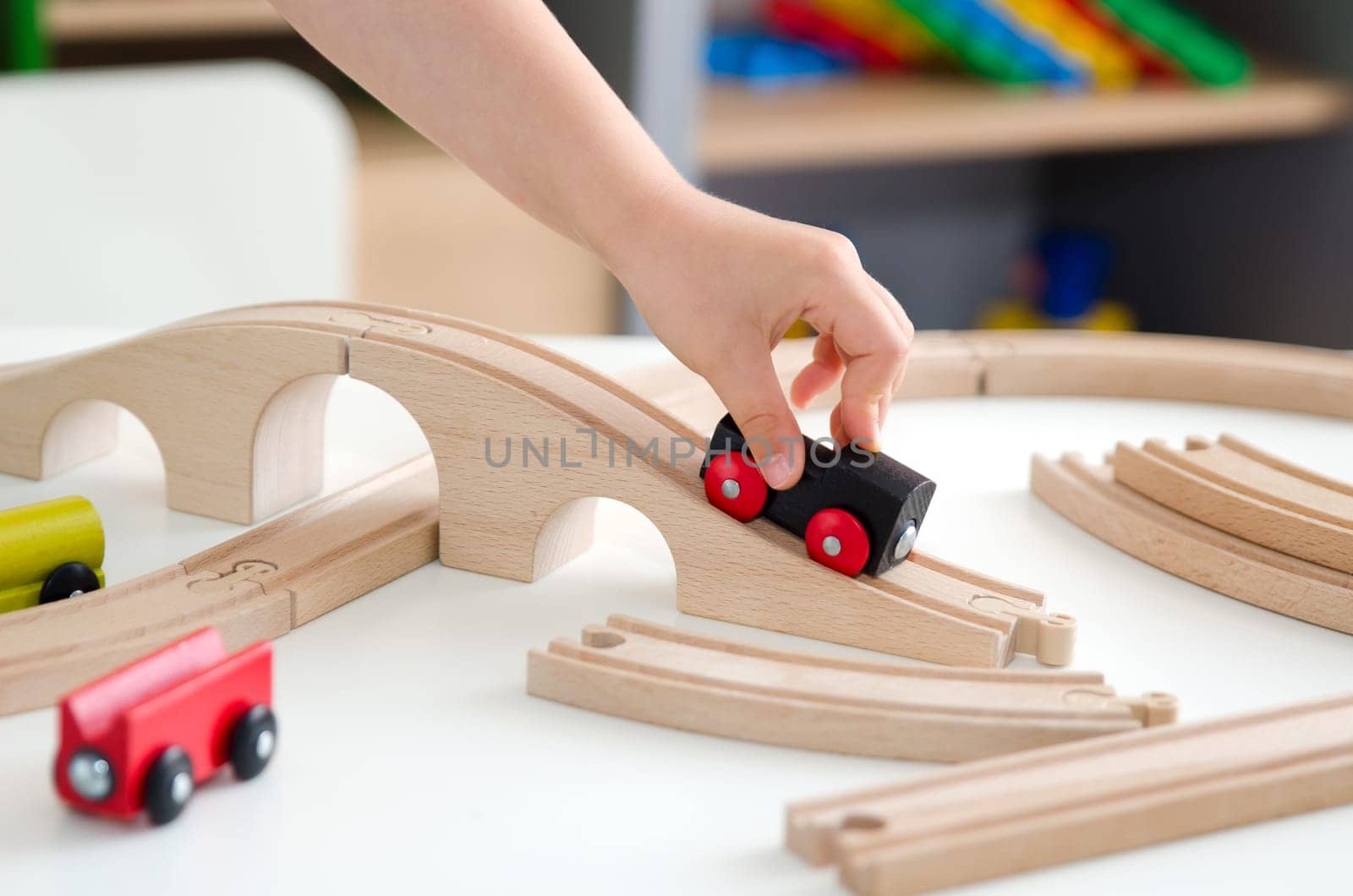 Child plays with a wooden toy train. toy wooden train toys education white background wood concept