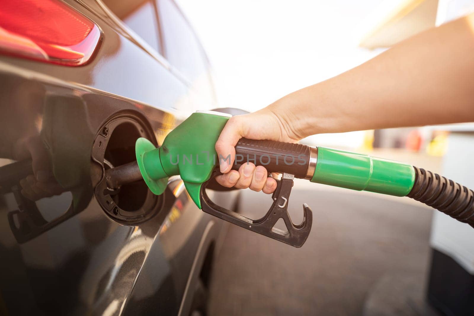 Closeup of man pumping gasoline fuel in car at gas station by simpson33